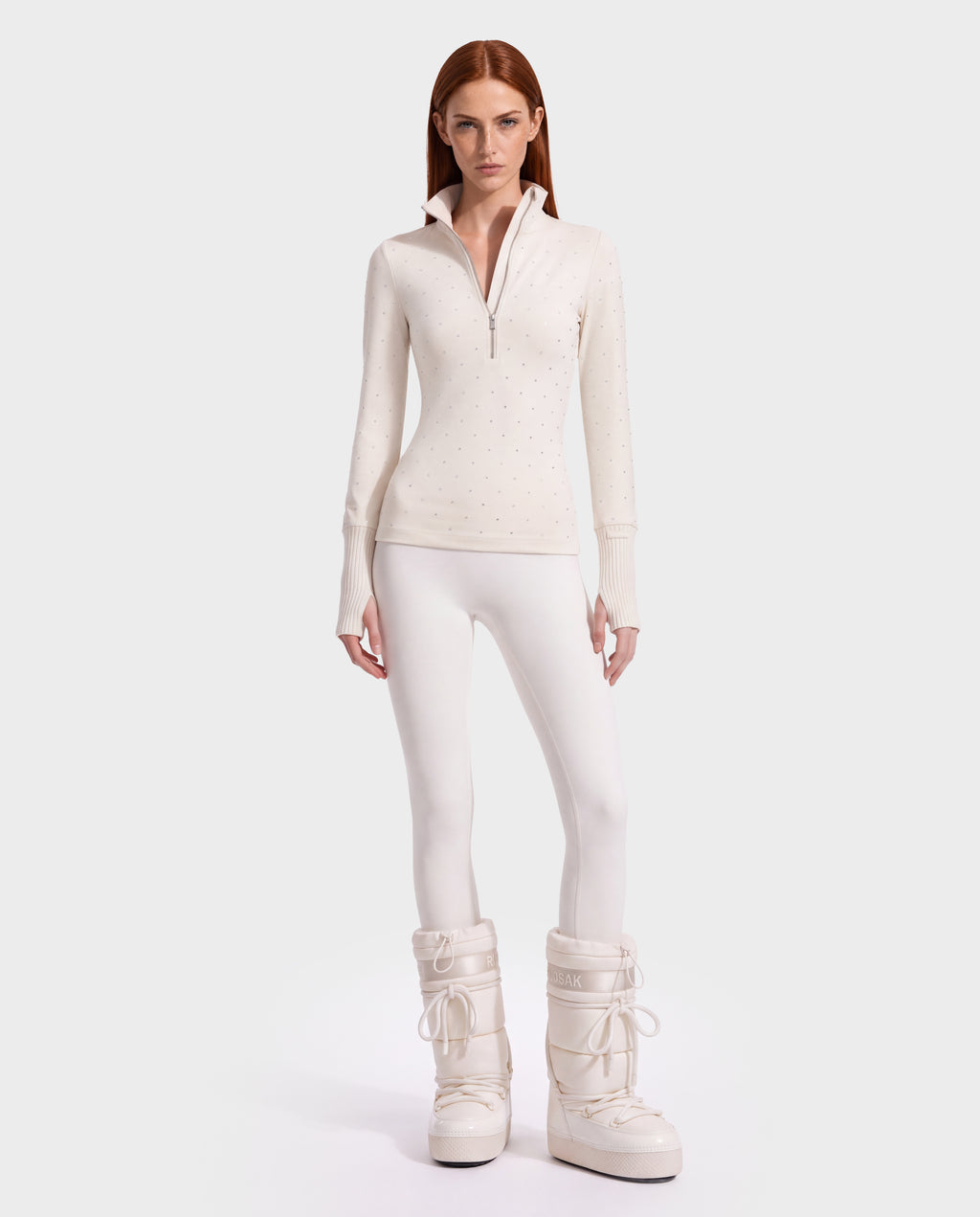 A model wearing a NEVA - 8526524 Vanilla crystal-scattered thermal long-sleeve quarter-zip top, white leggings, and chunky white winter boots.
