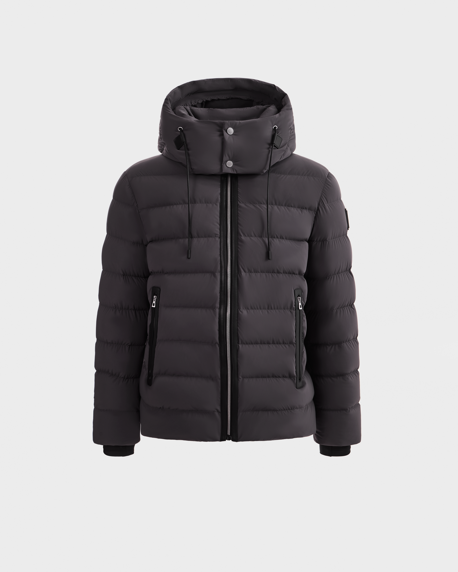The Rudsak NAVAN - 6125598 Grey is a grey quilted puffer jacket with a hood, front zipper, and two zippered side pockets, made with RDS-certified down, shown against a plain white background.
