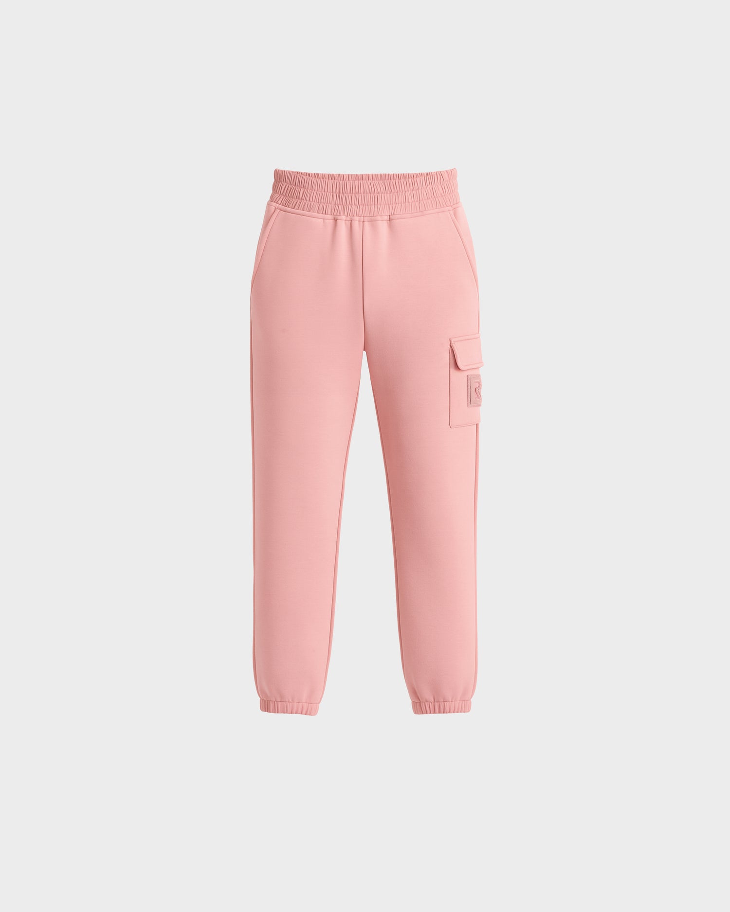 The NOOR - 1525004 Light Pink jogger pants by Rudsak feature an elastic waistband, side pockets, a right-leg cargo pocket, and elastic ankle cuffs. Shown on a plain white background.