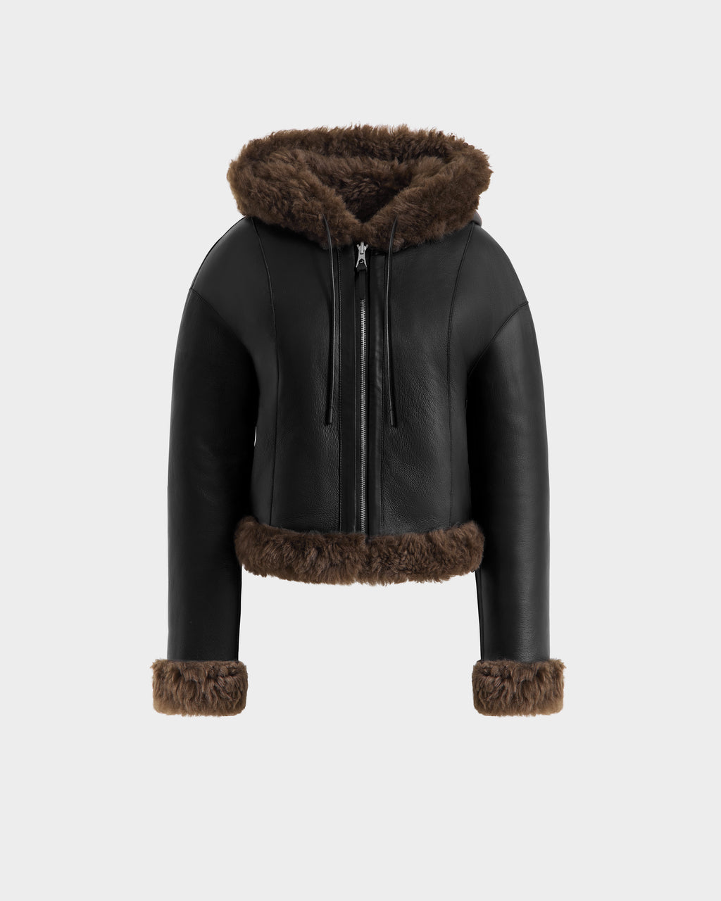 The Rudsak NORAH - 8125506 Black/Espresso womens reversible cropped jacket features black leather and espresso faux fur trim on the hood, cuffs, and hem, with a front zipper. Displayed on a light gray background.
