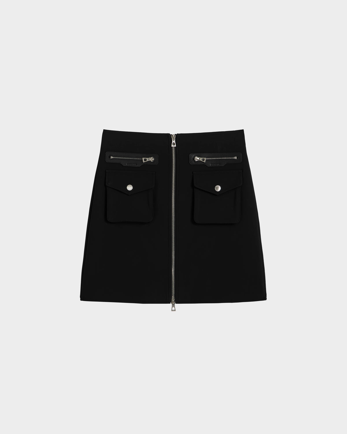 The Rudsak PAMINA - 8525025 Black is a women’s vegan leather mini skirt with a front zipper, utility pockets, and flap pockets with silver buttons, shown against a plain white background.