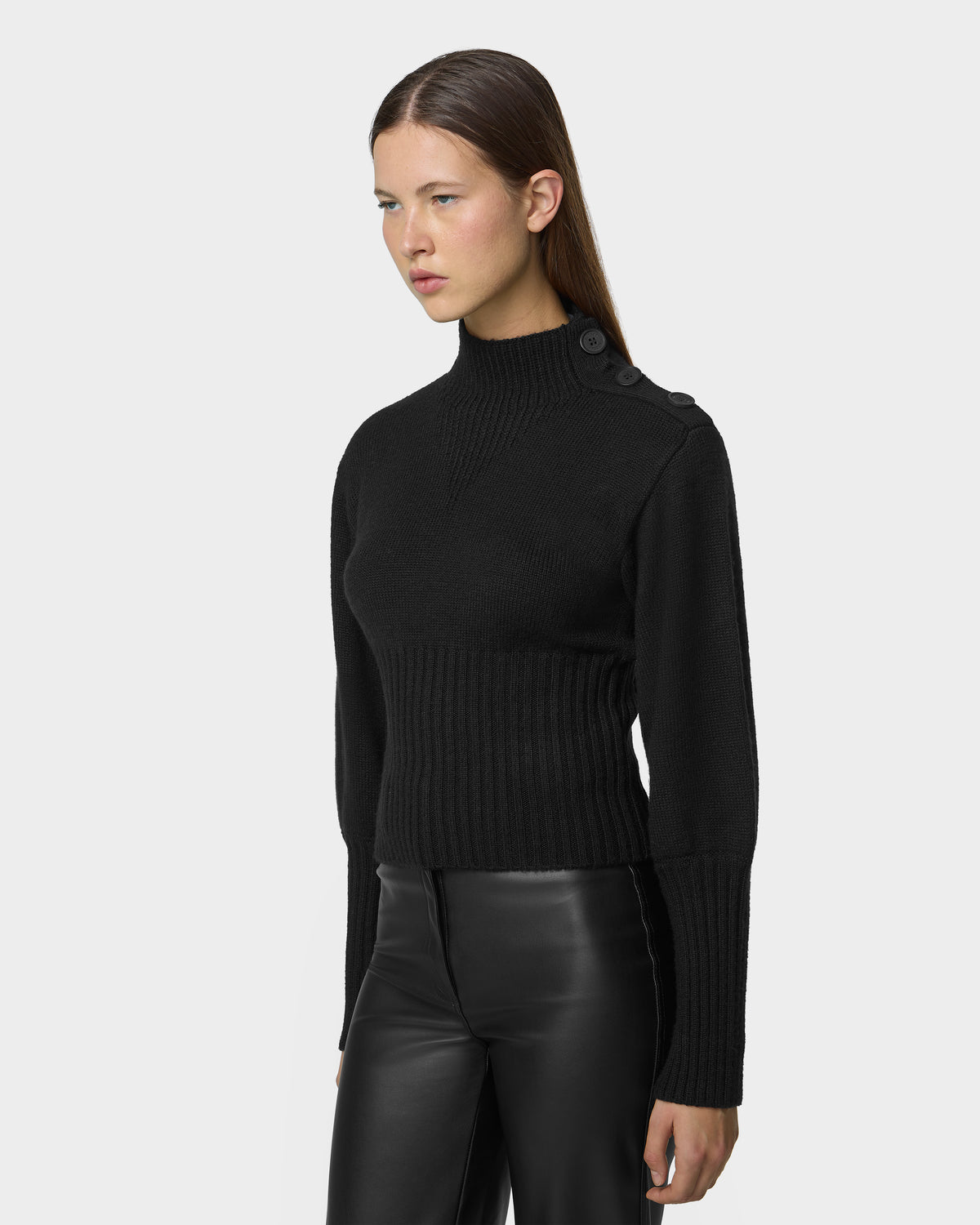 A person wears the black TATIANA - 8526694 long-sleeved sweater, featuring a ribbed mock neck and button detailing on the shoulder.