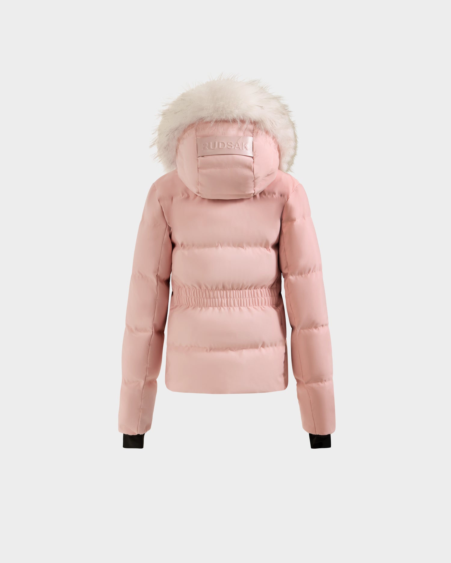 The Rudsak RAEGAN - 0125503 puffer jacket in pastel pink features a fur-lined hood with embossed branding, elastic waist, and black cuffs, shown on a plain white background.