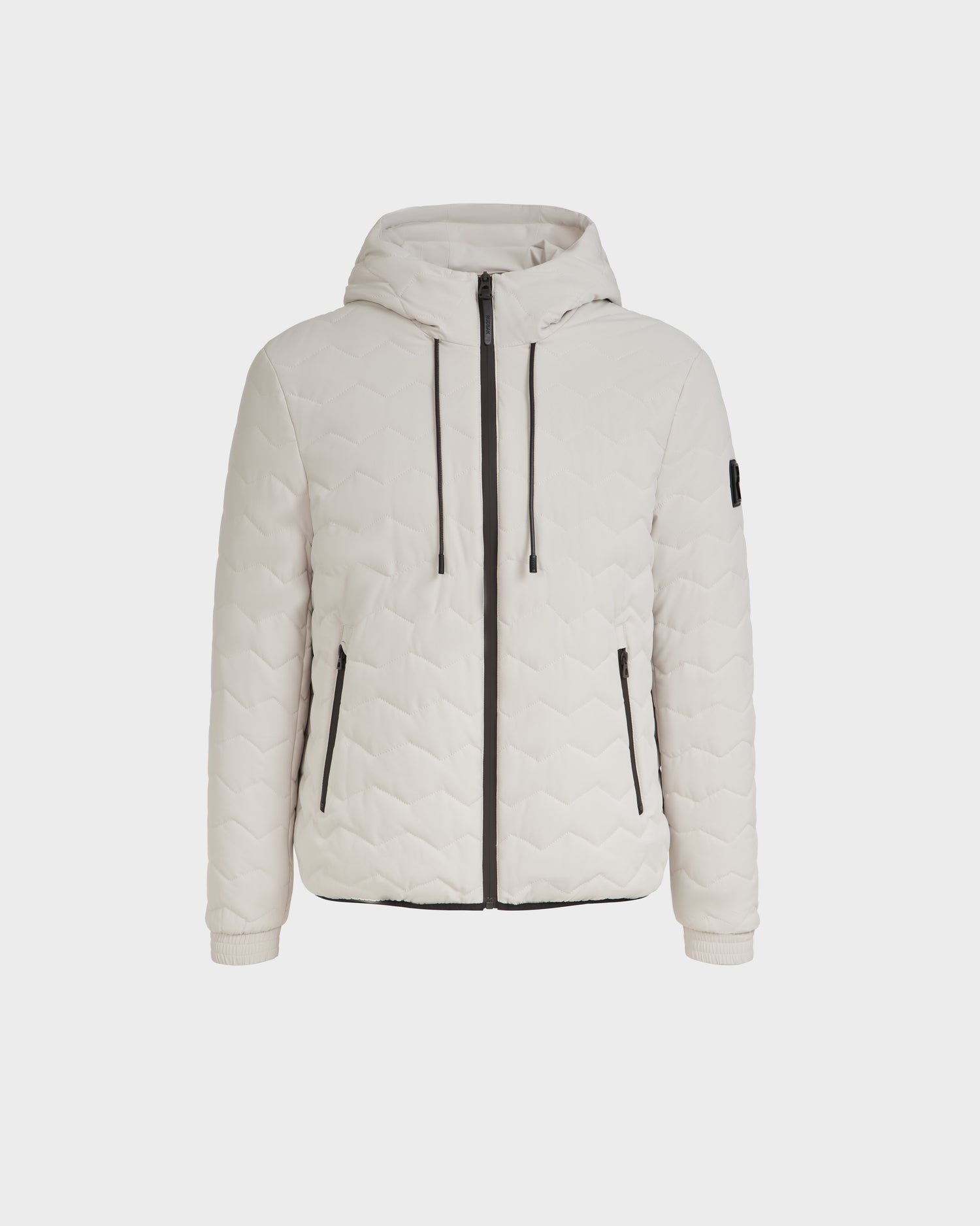 The RAFAEL - M125012 Vanilla by Rudsak is a light beige quilted jacket with a hood, eco-friendly fill, front zipper, black drawstrings, and black-trimmed zippered side pockets—ideal for transitional weather. Displayed on a plain white background.