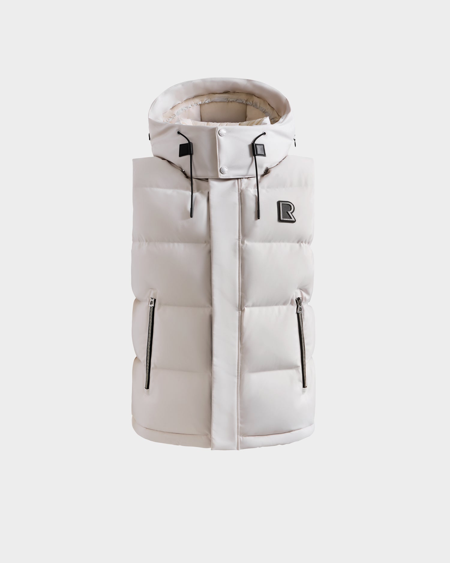The Rudsak REN H - 6125688 Vanilla men's quilted down puffer vest in light beige features a high collar, zipper closure, two front zippered pockets, and a black R logo on the chest—ideal for layering on chilly days.