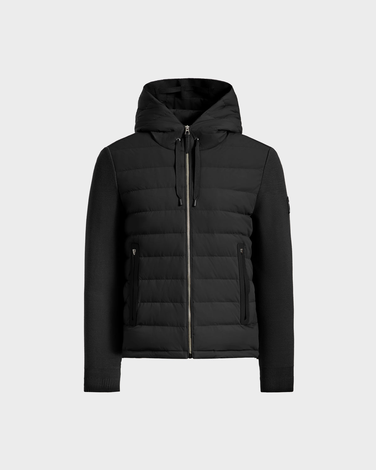 The Rudsak RIVER HV - H125503 Black is a limited edition hybrid hooded down jacket with quilted panels, knitted sleeves, and two zippered side pockets, shown on a plain light gray background.
