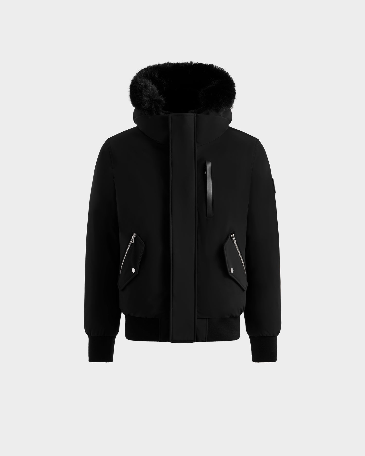 The Rudsak ROCKY - 6125682 Black men’s down bomber jacket is made from recycled nylon, with a fur-lined hood, front zipper, three zippered pockets, and ribbed cuffs and hem, shown on a plain light gray background.