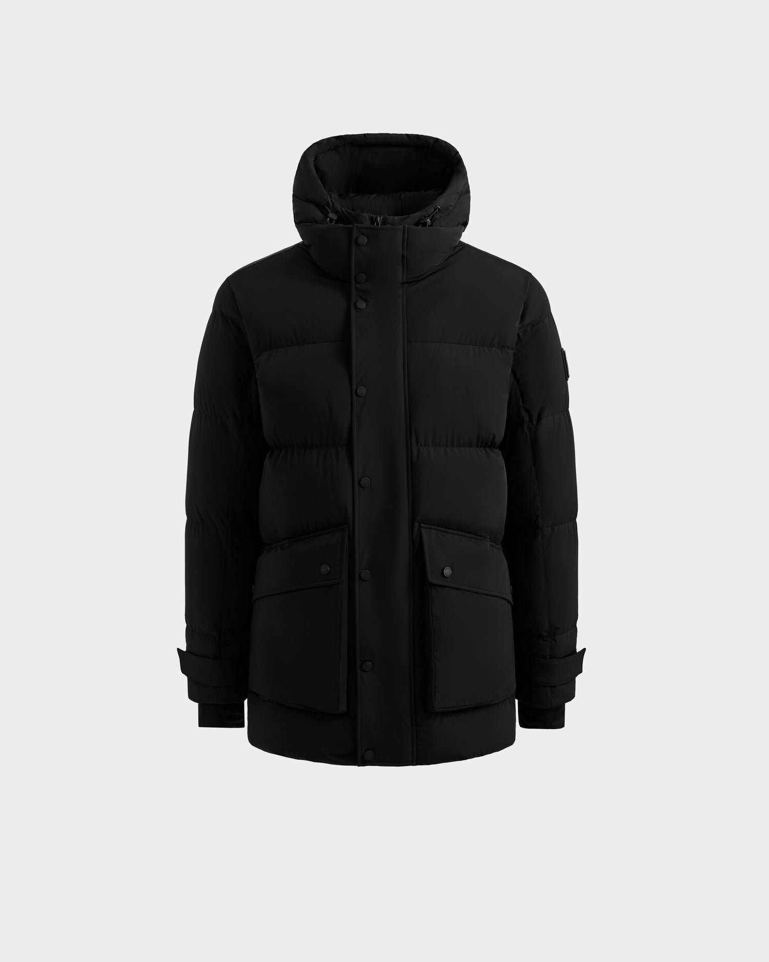 The Rudsak ROKO - 6124510 Black men's quilted down parka features RDS-certified insulation, a hood, front button closure, two large flap pockets, and adjustable cuff straps, shown against a plain light gray background.