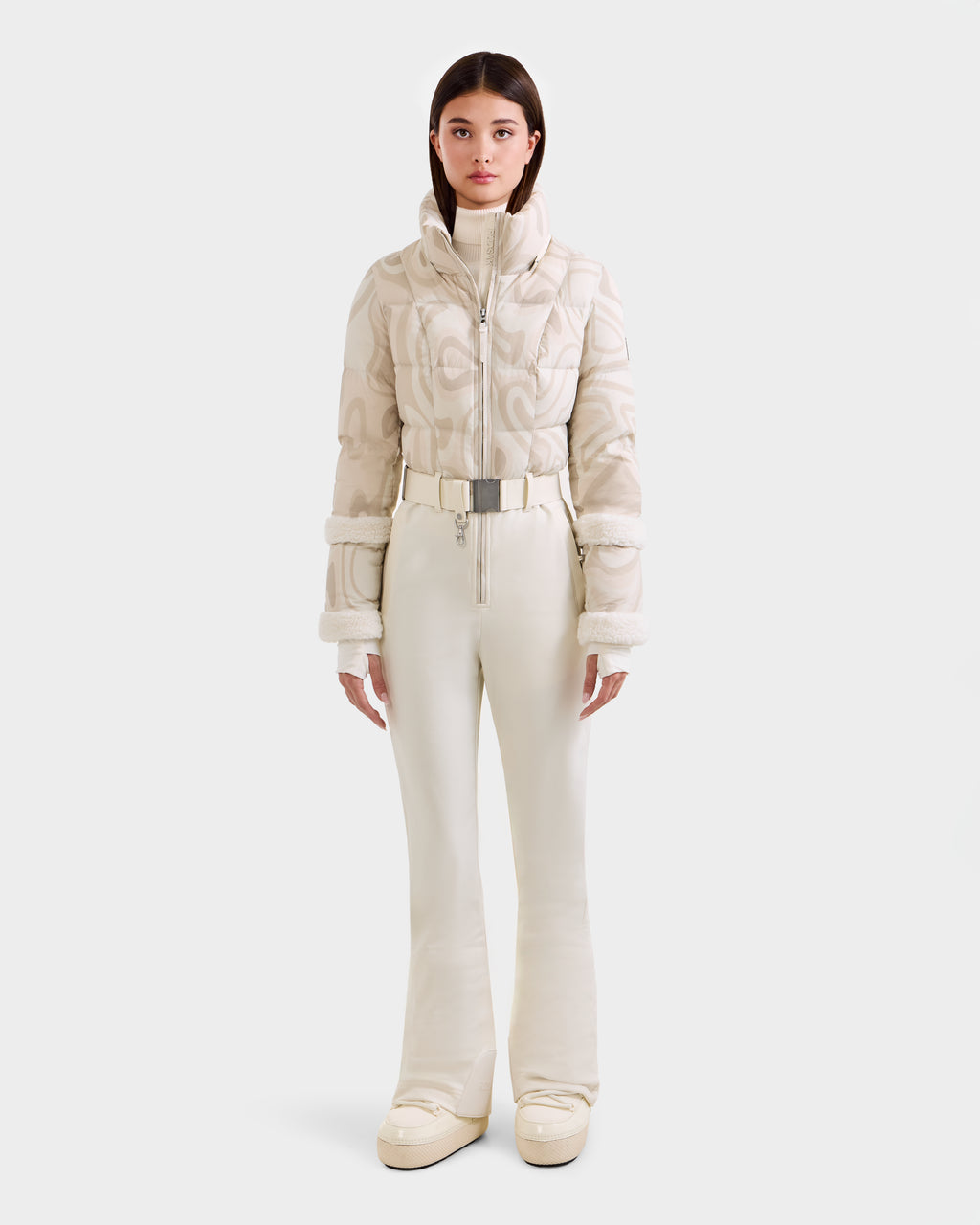 A woman faces forward in the Rudsak CARMEN P - 8125707 Vanilla Deja vu outfit: a chic cream quilted jacket, belted high-waisted pants, and platform shoes. Now available for pre-order; ships by November 30th.