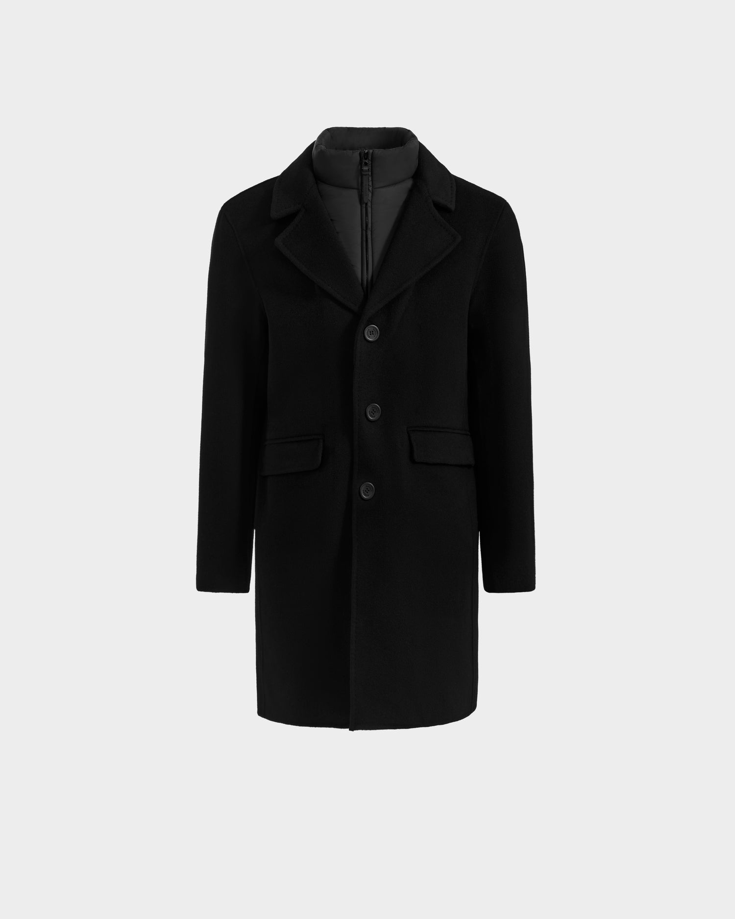 The Rudsak SAWYER - 6125511 Black men’s wool blend coat features a notched lapel collar, three-button front, flap pockets, and a quilted inner lining, shown against a plain light gray background.