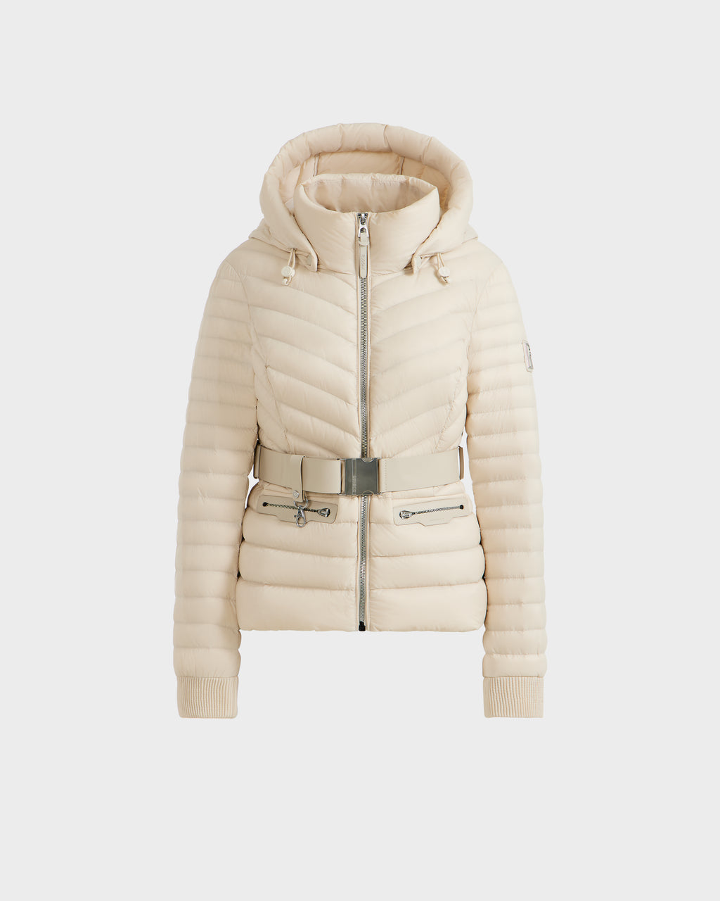 The Rudsak SCARLETT - 8125004 Vanilla is a cream quilted women’s lightweight down jacket featuring a hood, front zipper, ribbed cuffs, and a matching belt with metallic buckle at the waist.