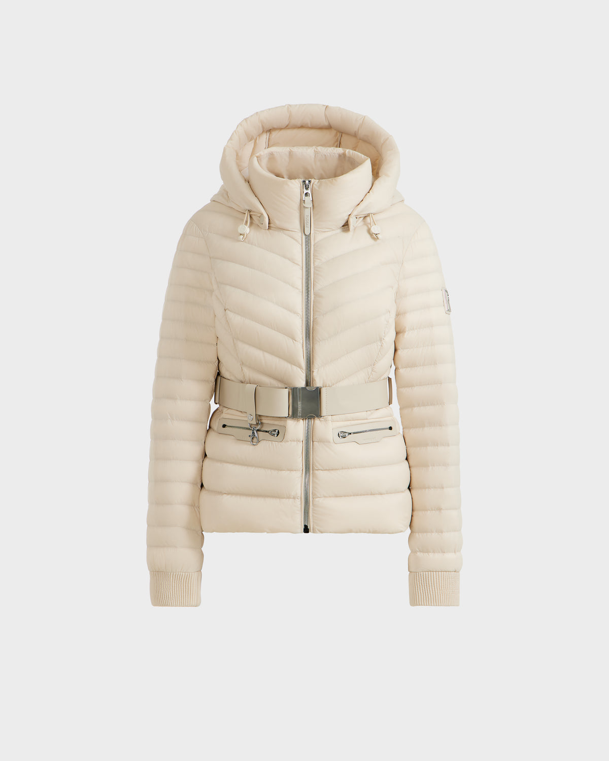The Rudsak SCARLETT - 8125004 Vanilla is a cream quilted women’s lightweight down jacket featuring a hood, front zipper, ribbed cuffs, and a matching belt with metallic buckle at the waist.