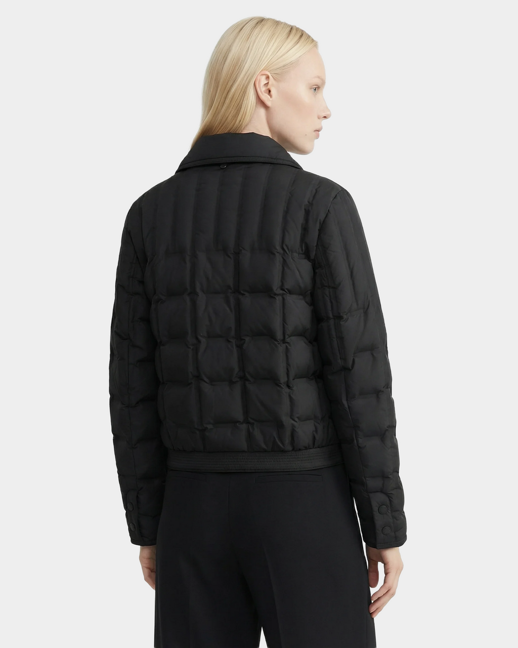 A person with straight blonde hair wears the Rudsak SEOUL - 8126027 Black quilted down-fill shirt jacket and matching black pants, facing away and slightly to the side against a plain white background.