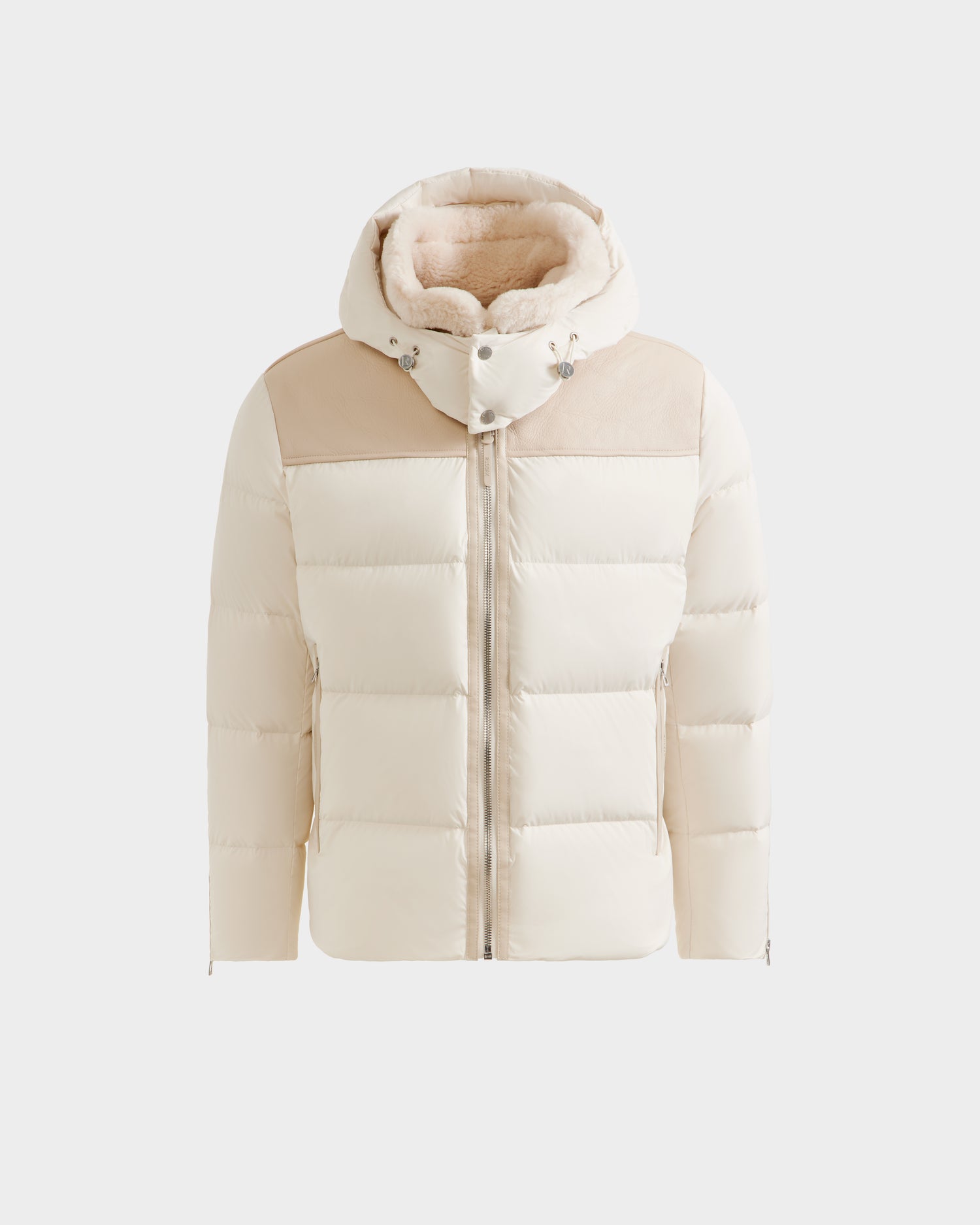 The Rudsak SIMON - 6125597 Vanilla is a cream men’s down puffer jacket with a hood, beige shoulder panels, front zipper, and plush light brown shearling collar lining, displayed on a plain white background.