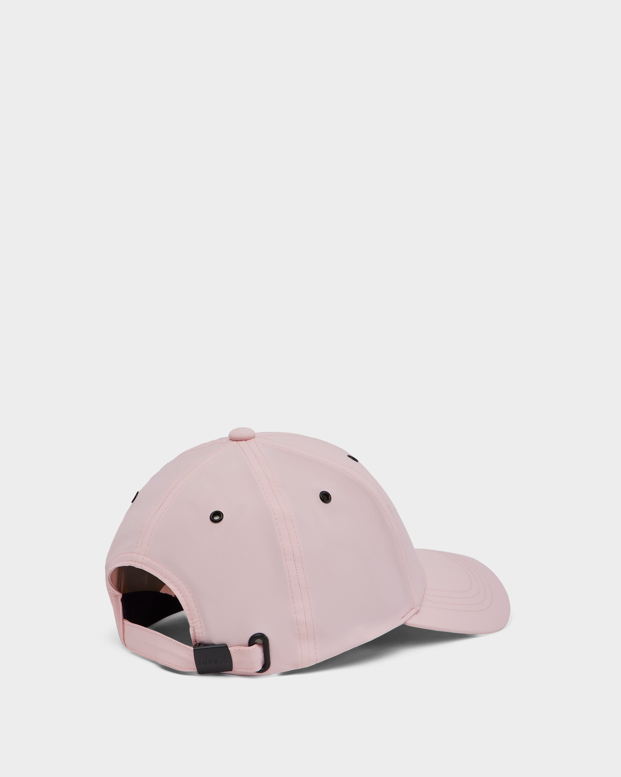 The Rudsak ARSENE - 9422504 Light Pink unisex baseball cap is shown from the back, with an adjustable strap and black ventilation eyelets against a plain white background.