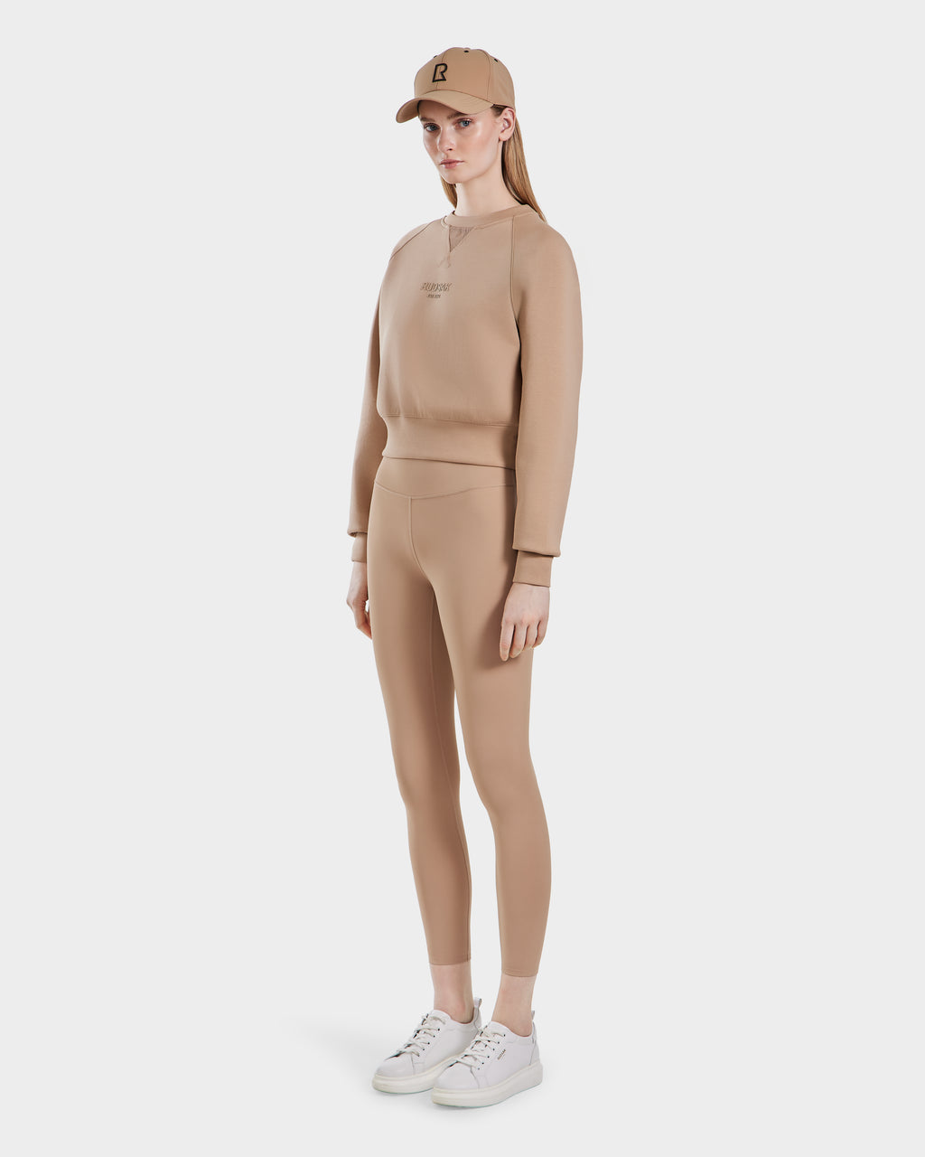 A woman wearing the Rudsak BETSY - 8525087 Almond premium cotton blend crewneck sweater.
