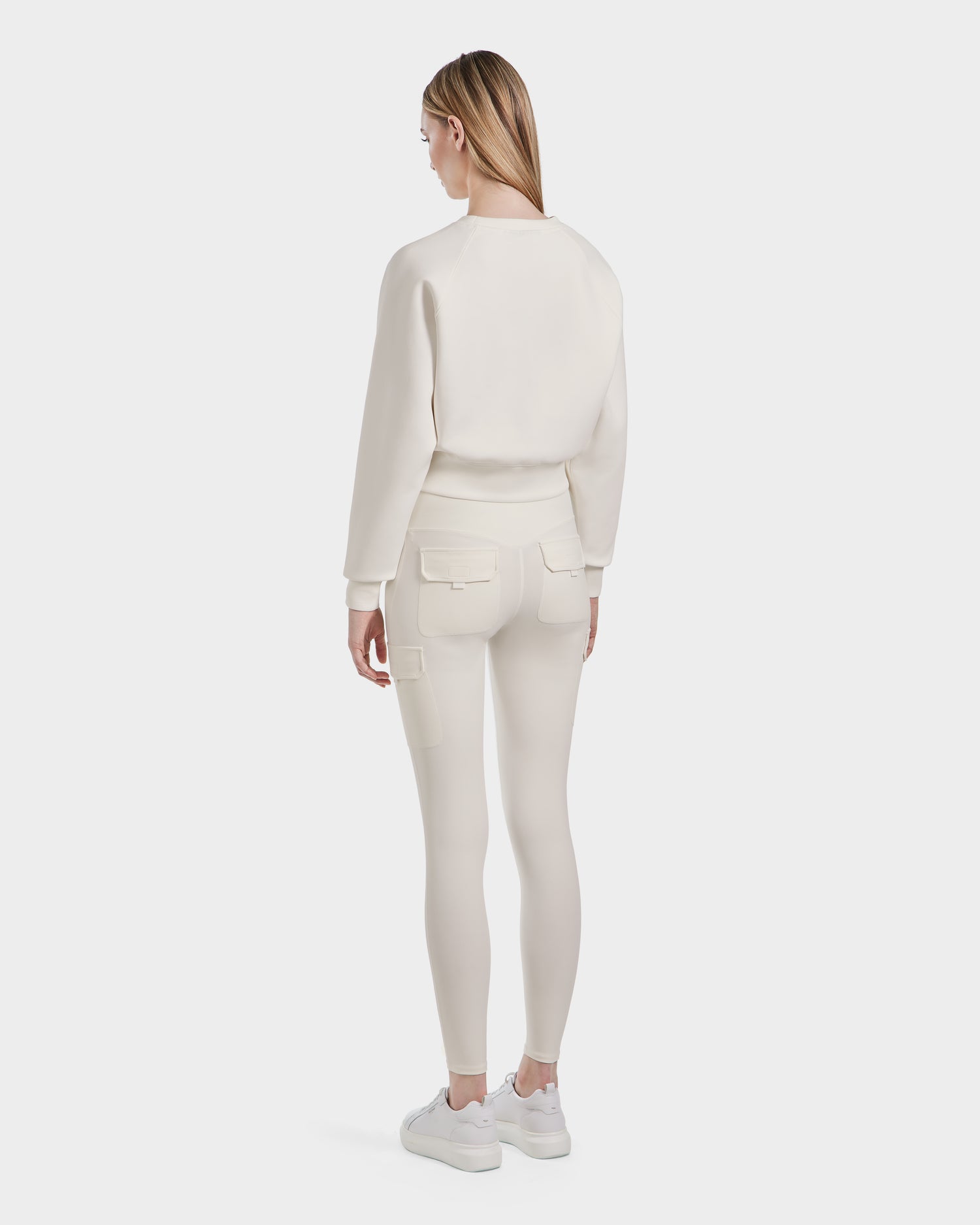 A woman with straight, light brown hair models the BETSY - 8525087 Iceland crewneck sweater and matching fitted cargo pants by Rudsak. She faces away, highlighting the back view against a plain white background.