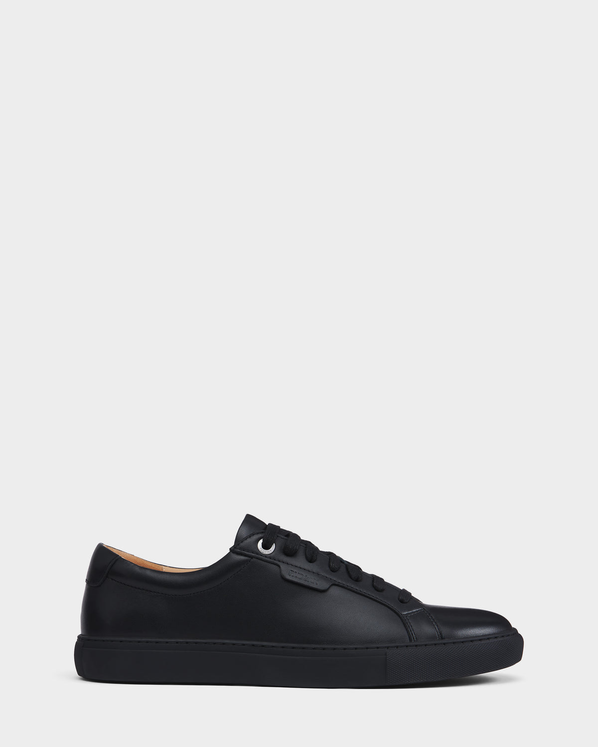 The LARIS - 6225000 Black by Rudsak is a black low-top lace-up sneaker with black laces, a black sole, and minimal stitching, shown in side profile against a plain white background.