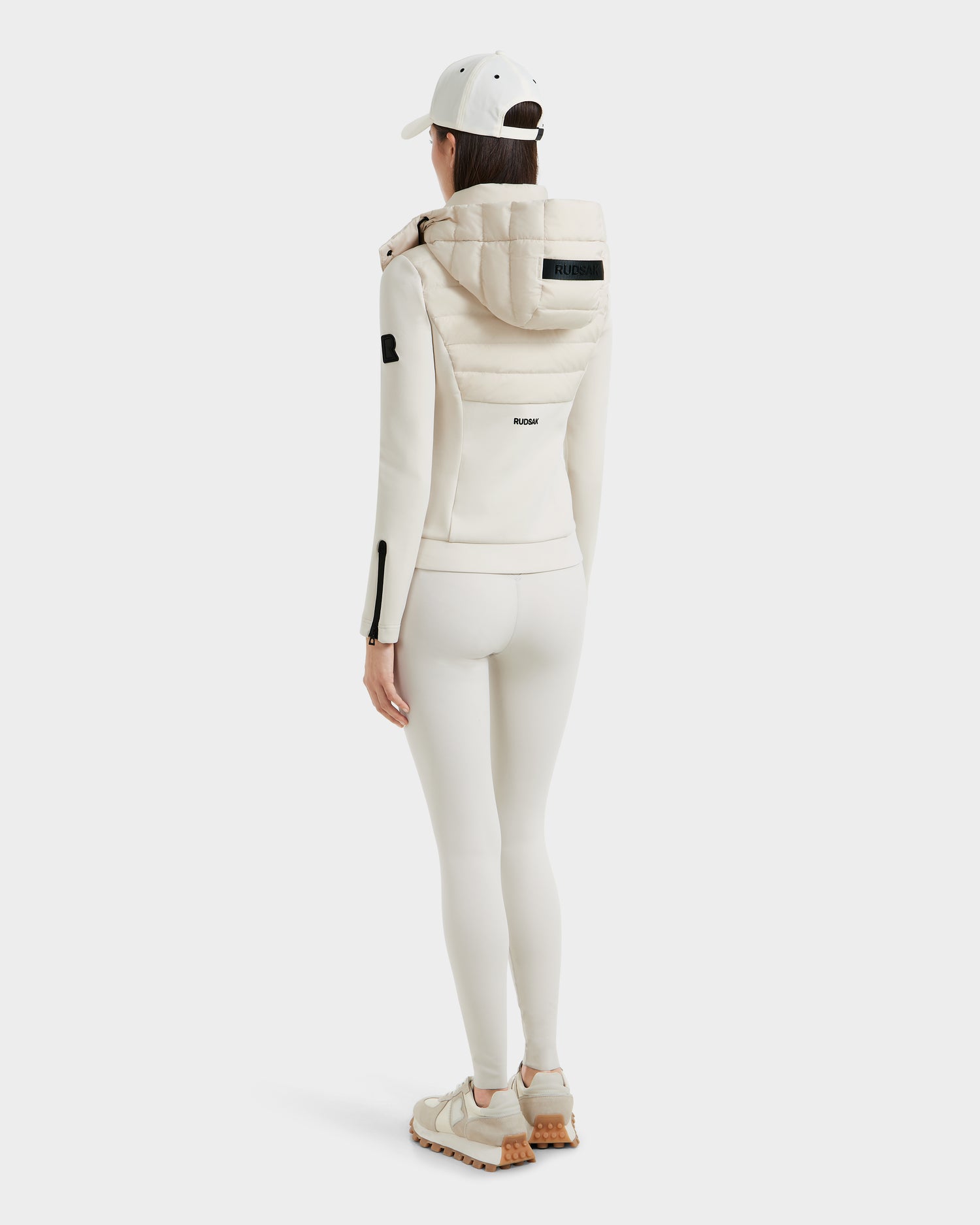 A woman in Rudsak’s MABS - 8125055 Vanilla activewear stands facing away from the camera, dressed head-to-toe in white sportswear against a plain white background.