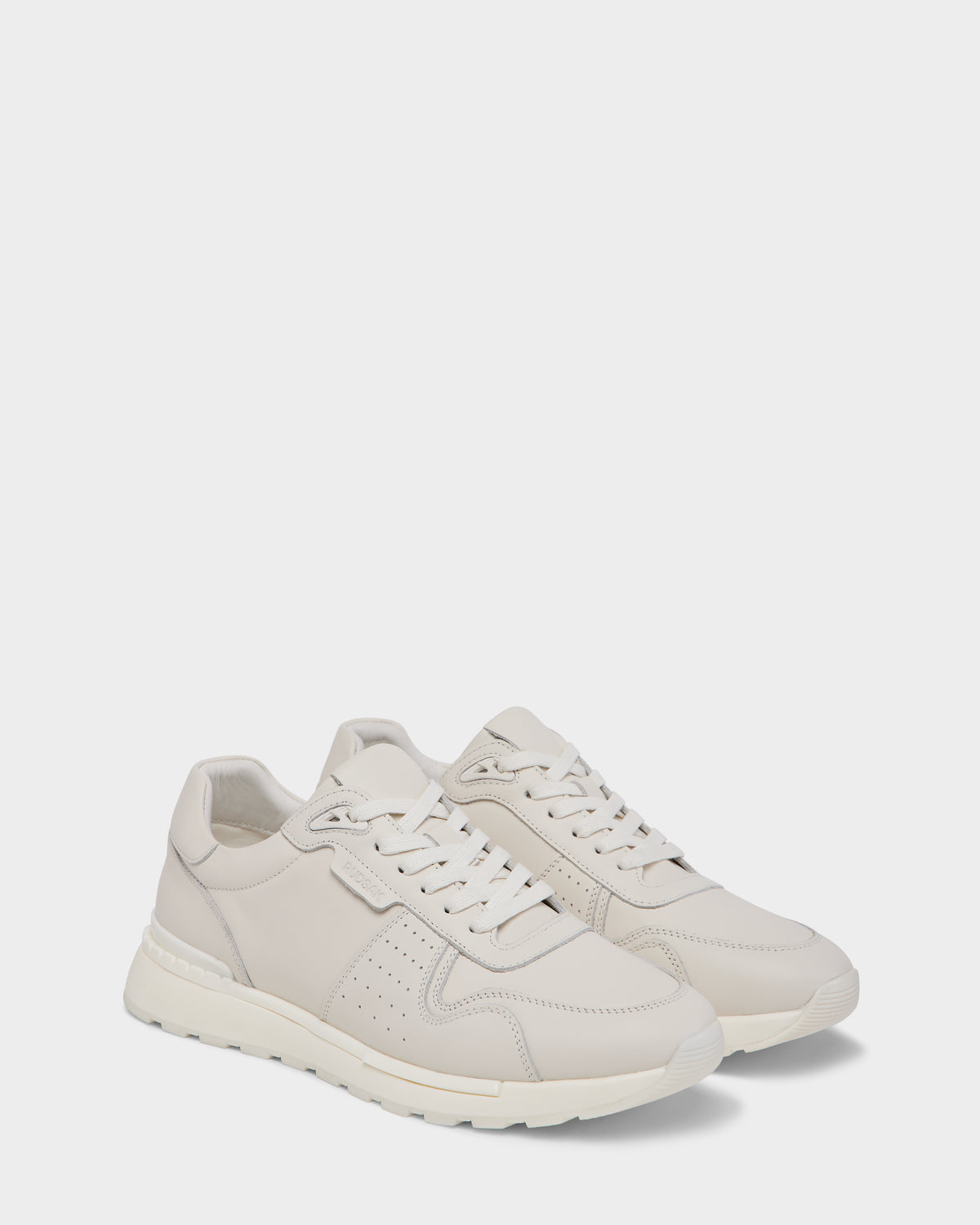 The Rudsak MALONE - 6225010 Iceland offers off-white men’s leather sneakers with white soles, laces, and subtle stitching—expertly crafted for everyday wear—shown side by side on a simple light background.