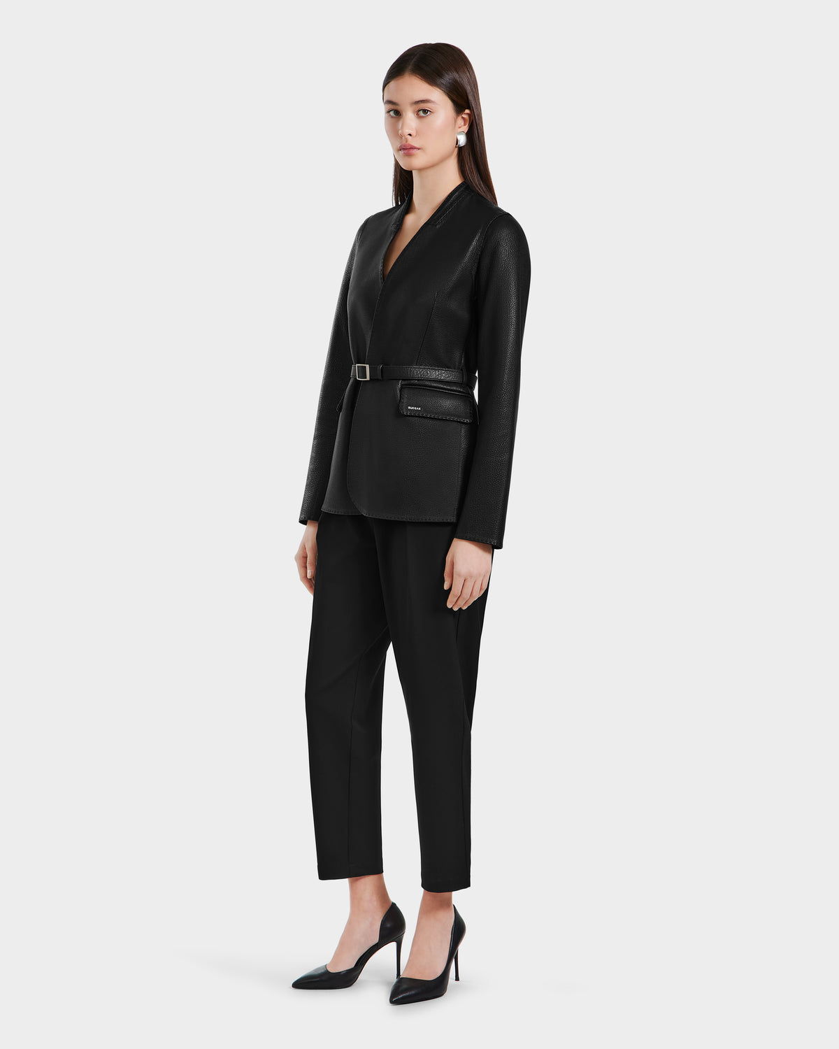 A woman in the Rudsak PAMILA - 8125051 Black leather blazer exudes minimalist sophistication, making it a versatile essential for any modern wardrobe.