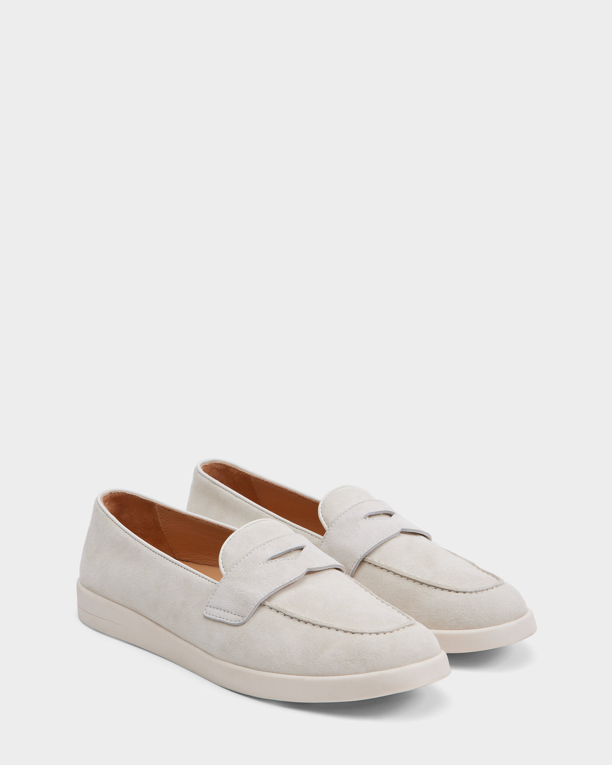The Rudsak RABECCA - 8225006 Iceland is a light beige suede womens loafer with a low heel, rounded toes, penny strap, and visible stitching—luxuriously crafted slip-ons shown on a plain white background.