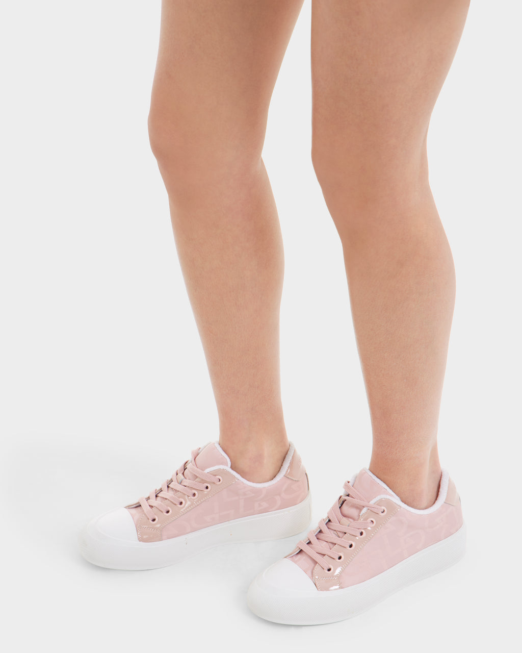 A person wearing Rudsak RIMA - 8225001 Blush Pattern women’s platform sneakers in light pink with white toe caps and soles, standing on a white background. Only their legs and feet are visible.