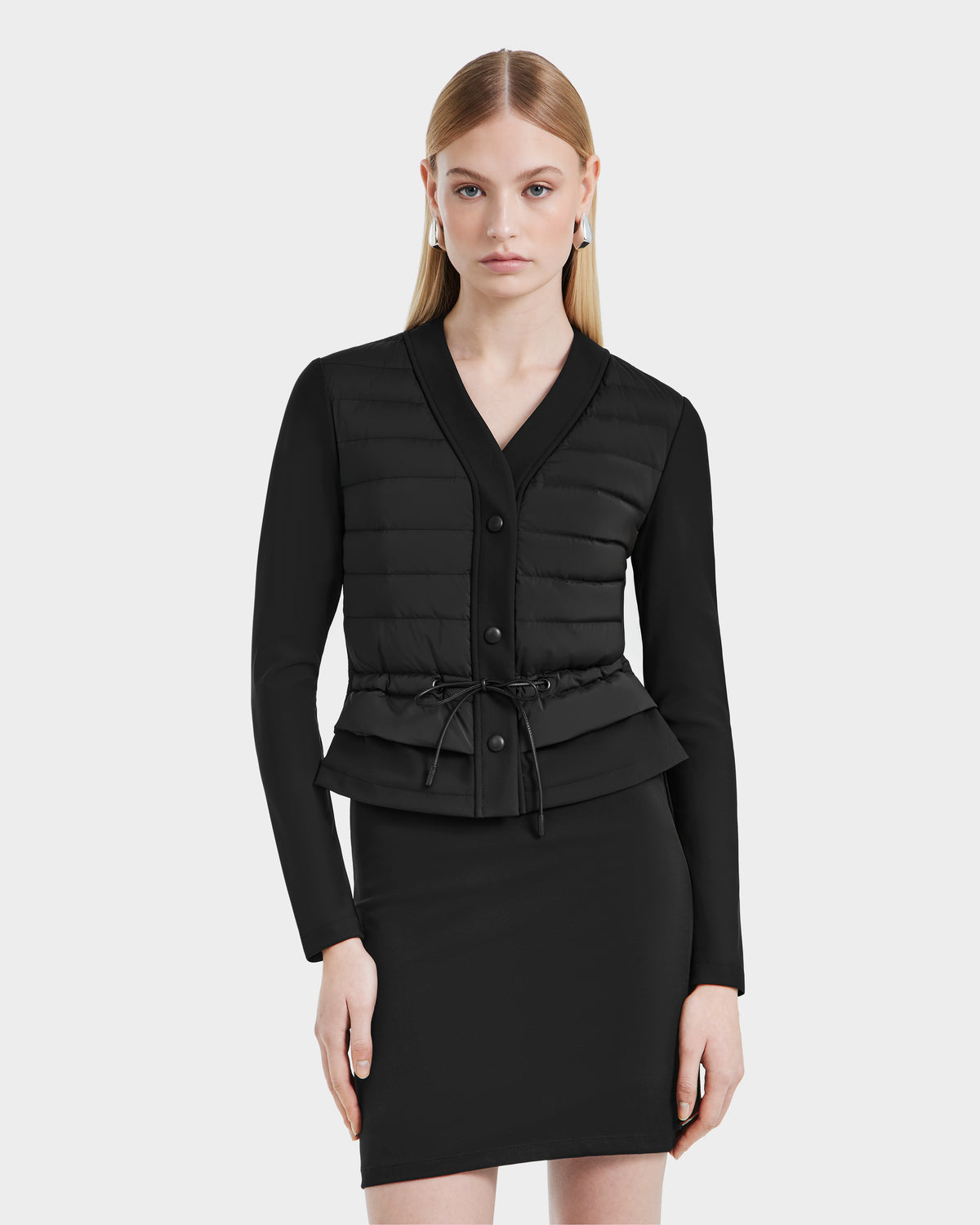 A woman wearing Rudsak’s SAMANTHA - 8125043 Black quilted down cardigan, the perfect versatile layering piece for any wardrobe.