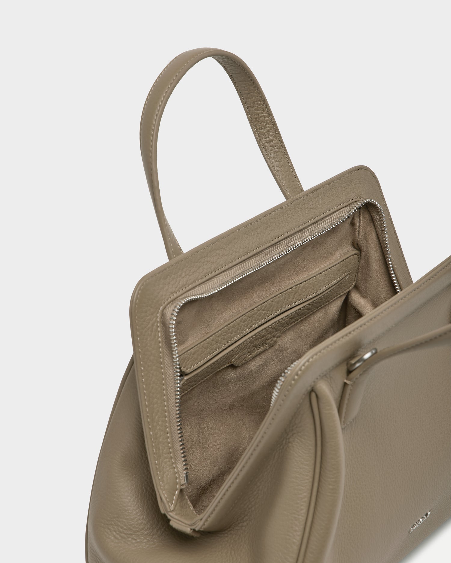 The TAULLA - 8325002 Almond by Rudsak is a taupe women’s pebble leather satchel with a top handle, spacious interior, zip pocket, card slots, and a removable shoulder strap for versatile carry.