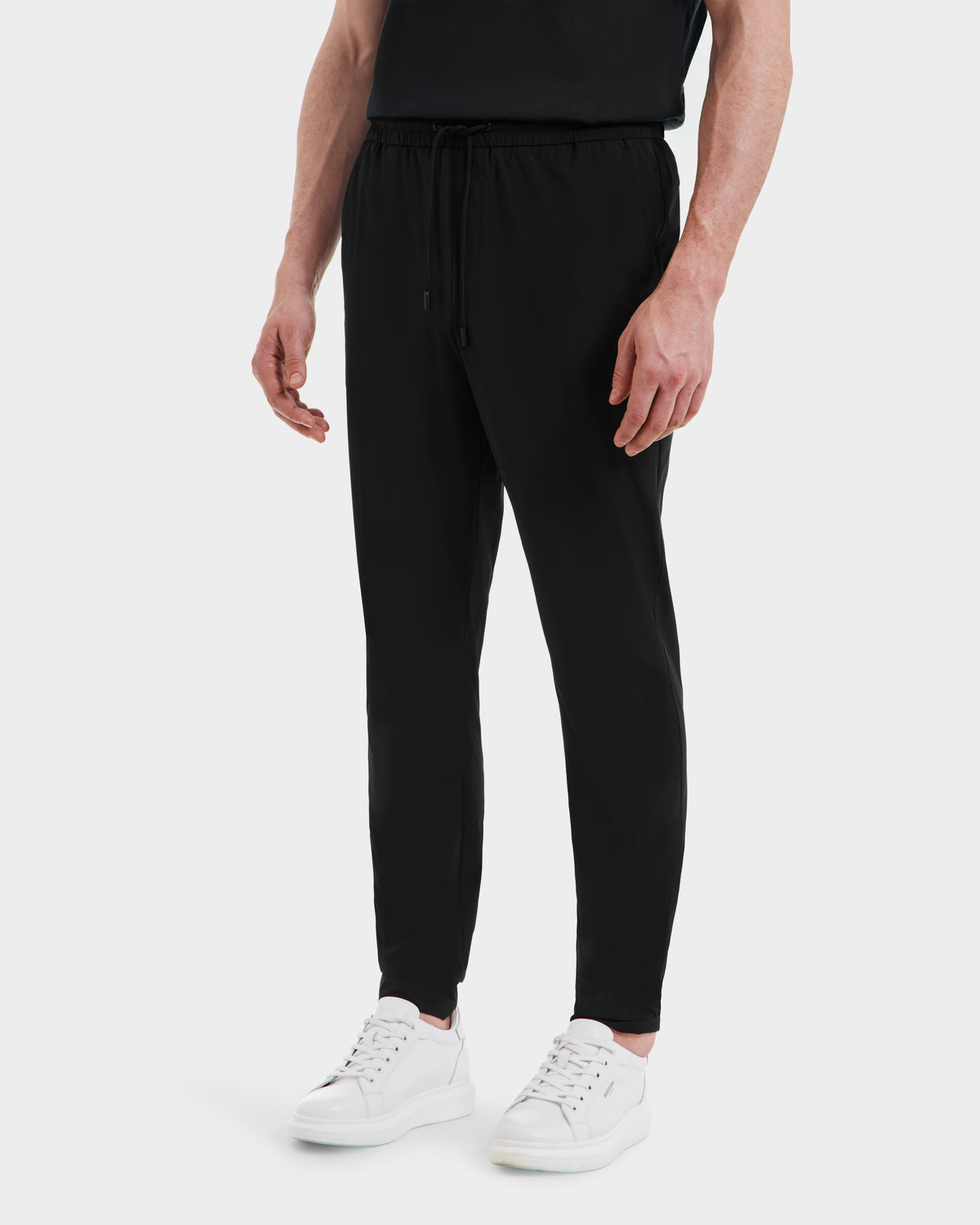 A man wearing Rudsak TUSTIN - 6525029 black mens casual pants and white shoes.