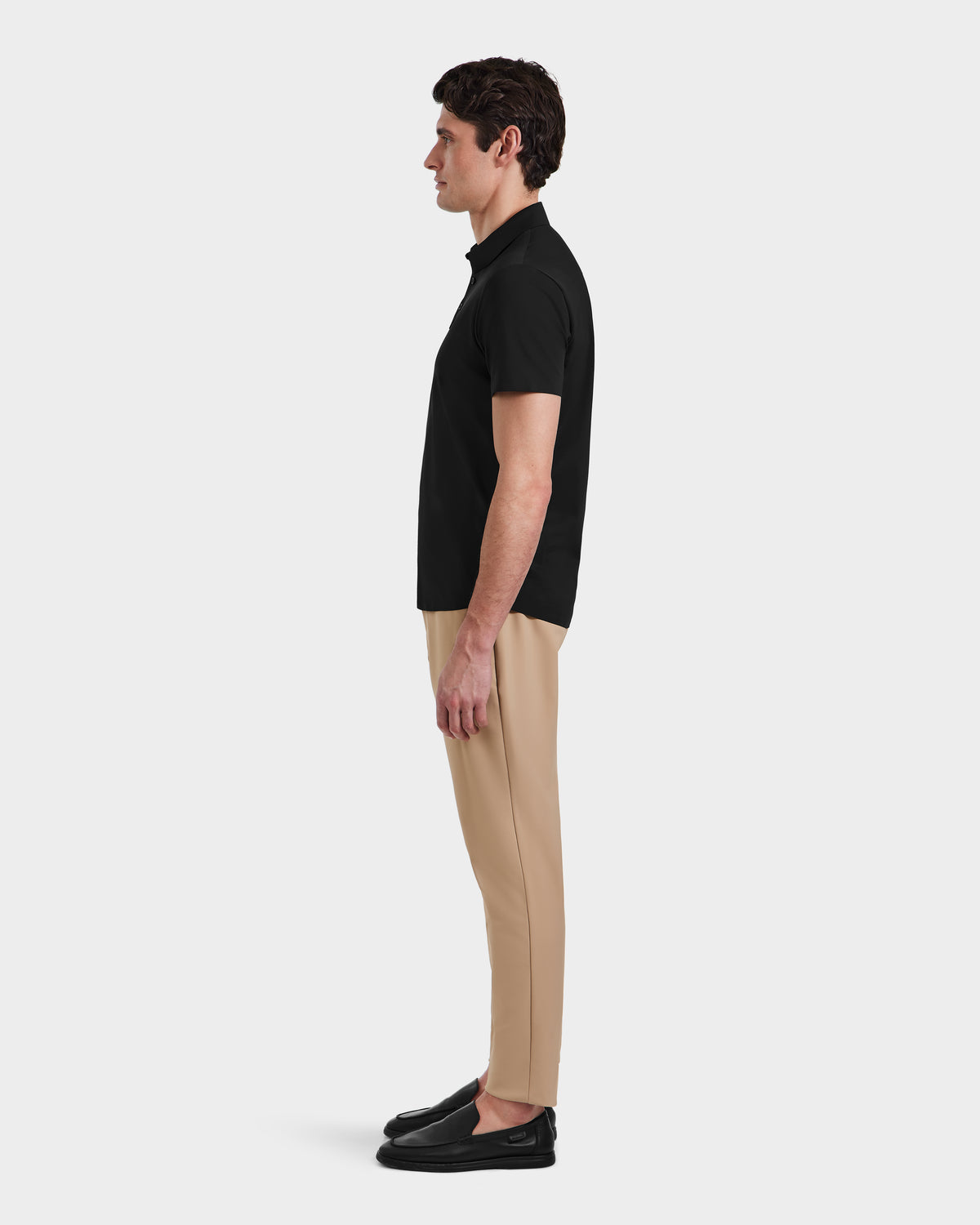 A man in a tailored-fit black WELLS - 6525017 shirt by Rudsak and tan pants showcases modern mens essentials.