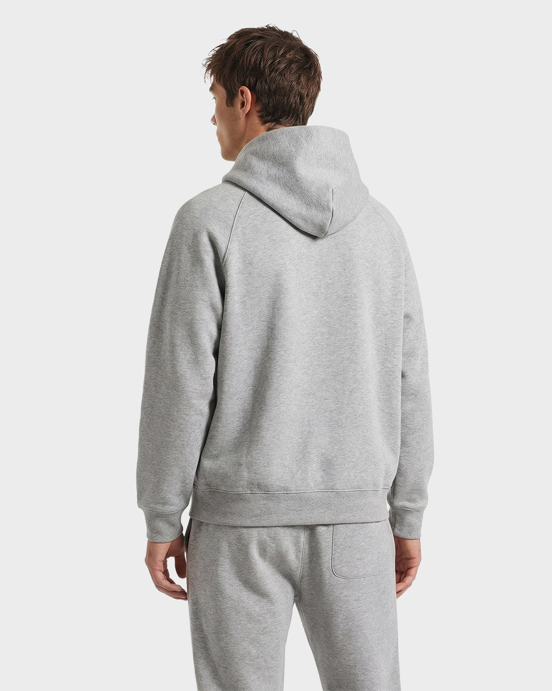 A person wearing Rudsak's BRIAR - 9525001 Heather Grey M unisex hoodie and sweatpants made from premium cotton blend is seen from the back against a plain white background.