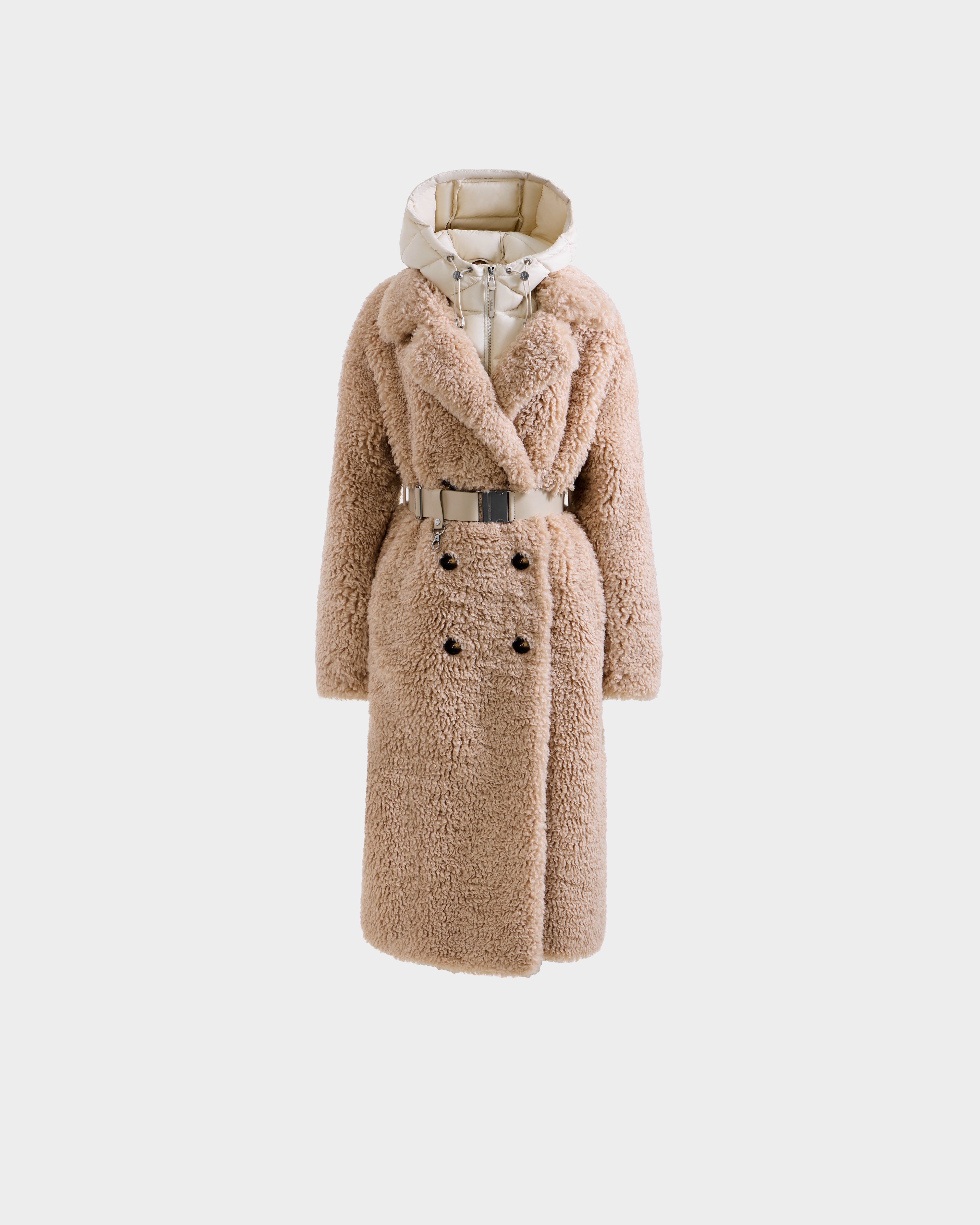 The Rudsak TINA - 8125968 Vanilla is a long, beige faux fur teddy trench coat with a wide collar, double-breasted buttons, matching belt, and removable hooded bib, shown against a plain white background.