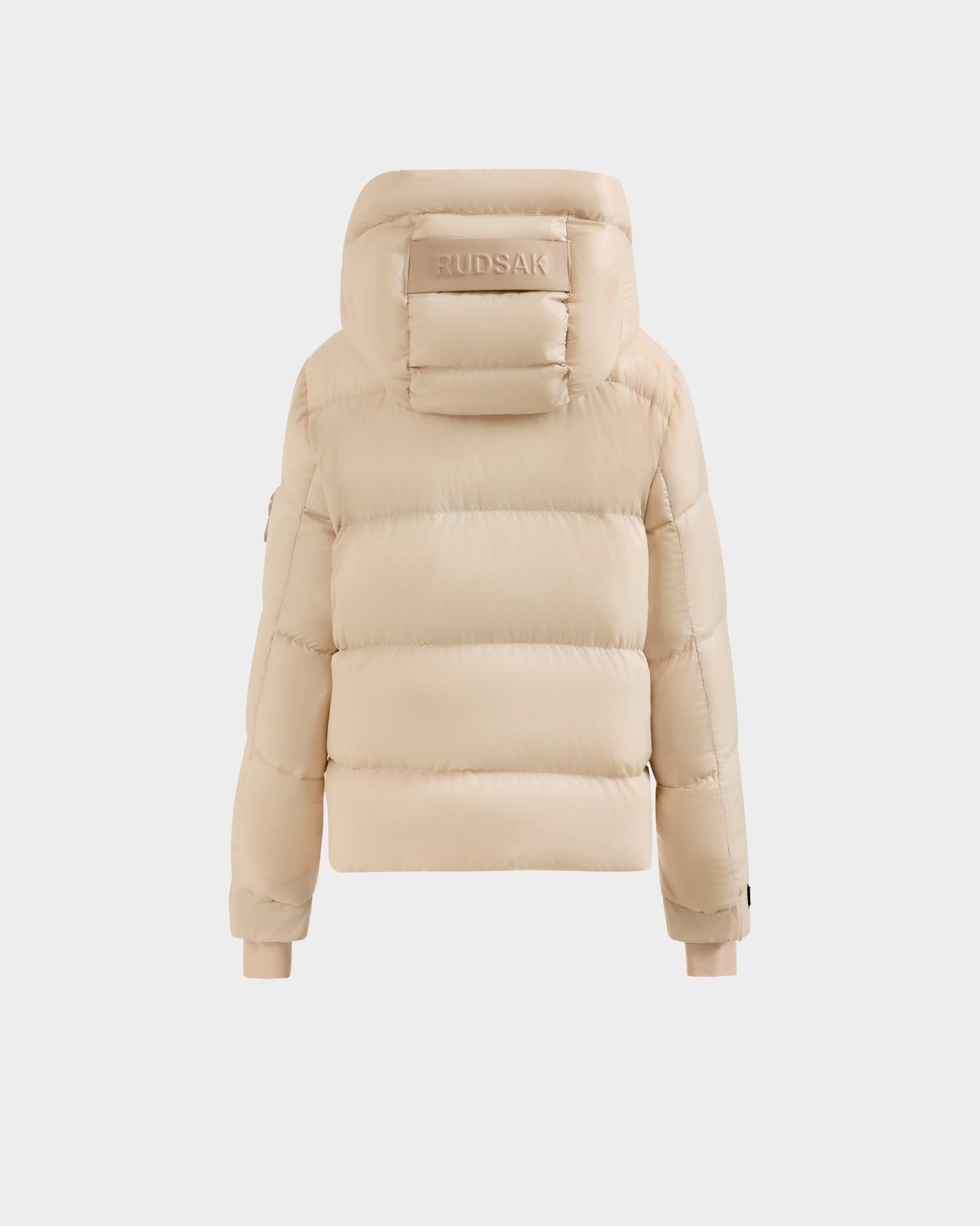 The VINCE KS - 0124502 Vanilla by Rudsak is a beige unisex puffer jacket with a hood embossed with "RUDSAK." This quilted design features ribbed cuffs and is filled with RDS-certified down for warmth and comfort.