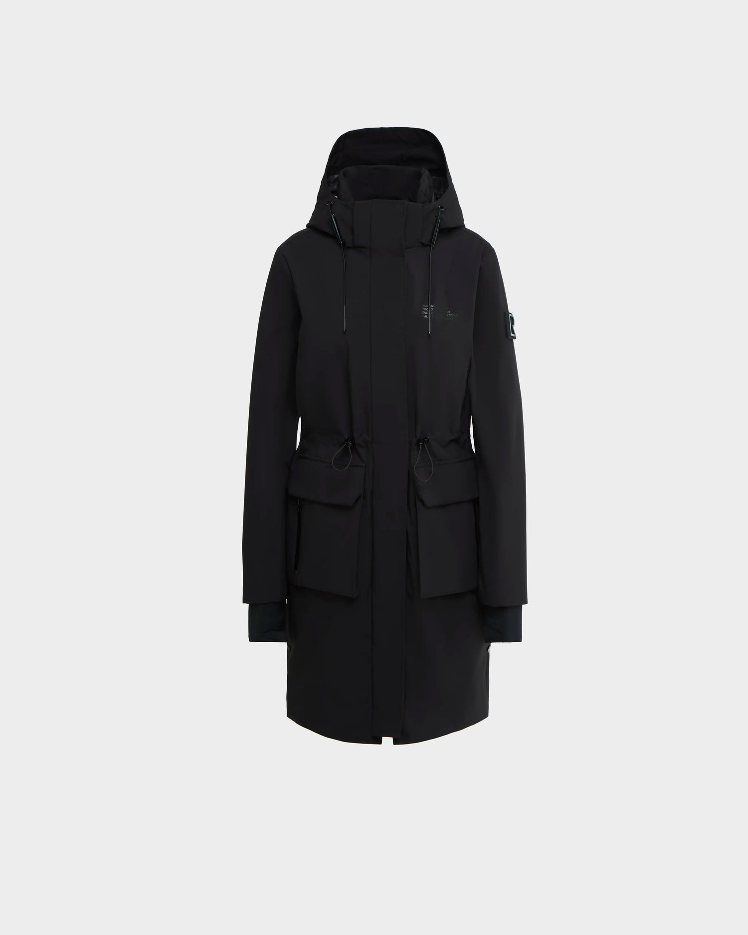 The NICOLE - L123002 Black by Rudsak is a black knee-length parka with large front pockets, adjustable waist drawstrings, and long sleeves, shown against a plain light gray background.