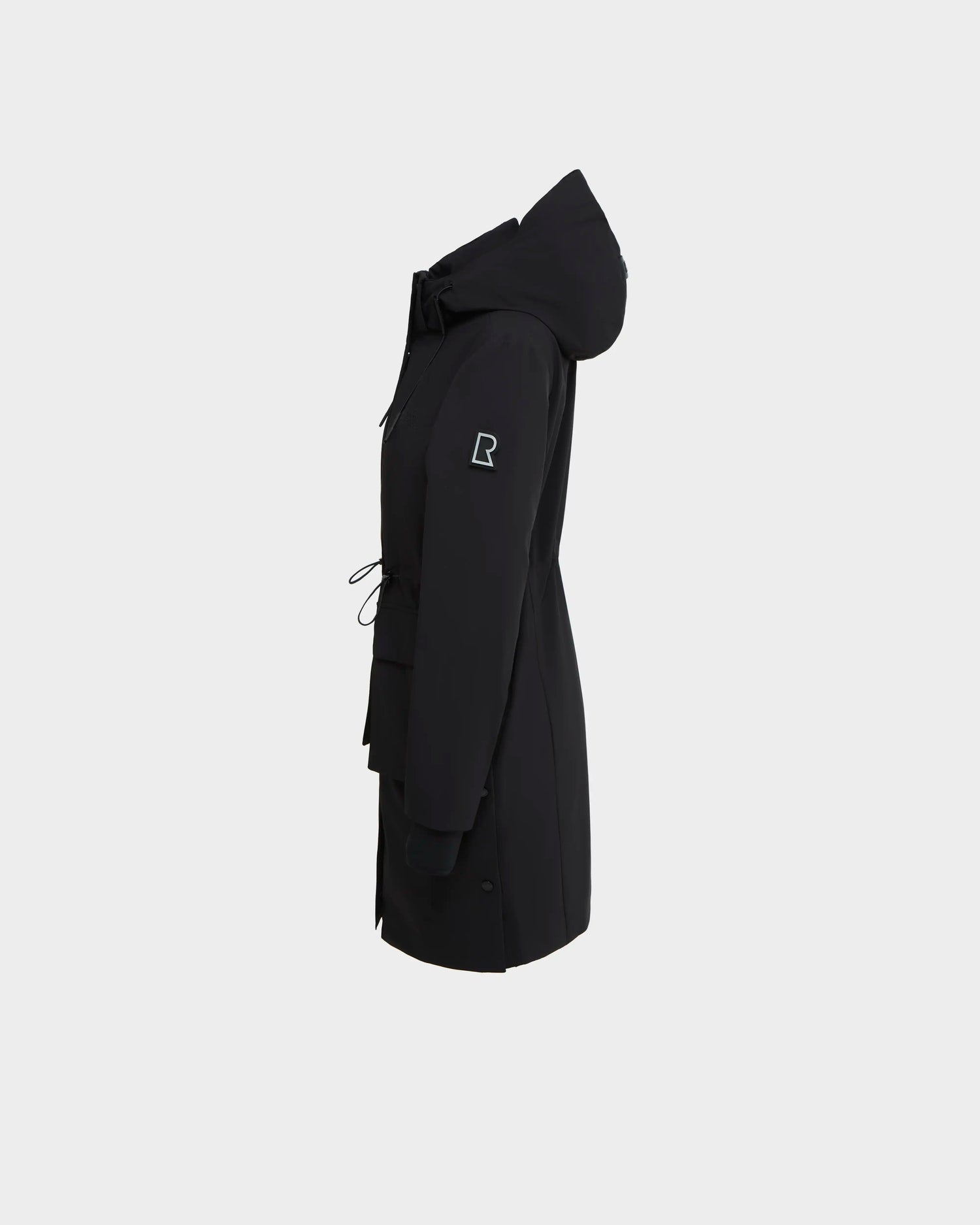 The Rudsak NICOLE - L123002 Black raincoat is shown side-on against a white background, featuring a hood, drawstring waist, and a logo patch on the upper sleeve for style.