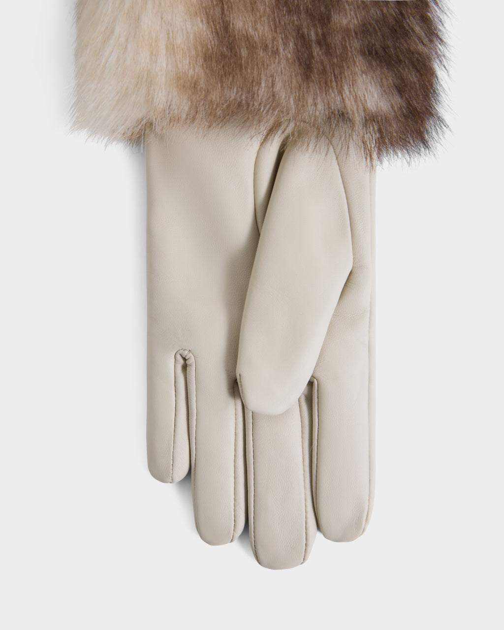 A pair of Rudsak ZAYLA - 8426712 Vanilla beige leather gloves lies flat, with a piece of fur partially covering the top, all set against a white background.