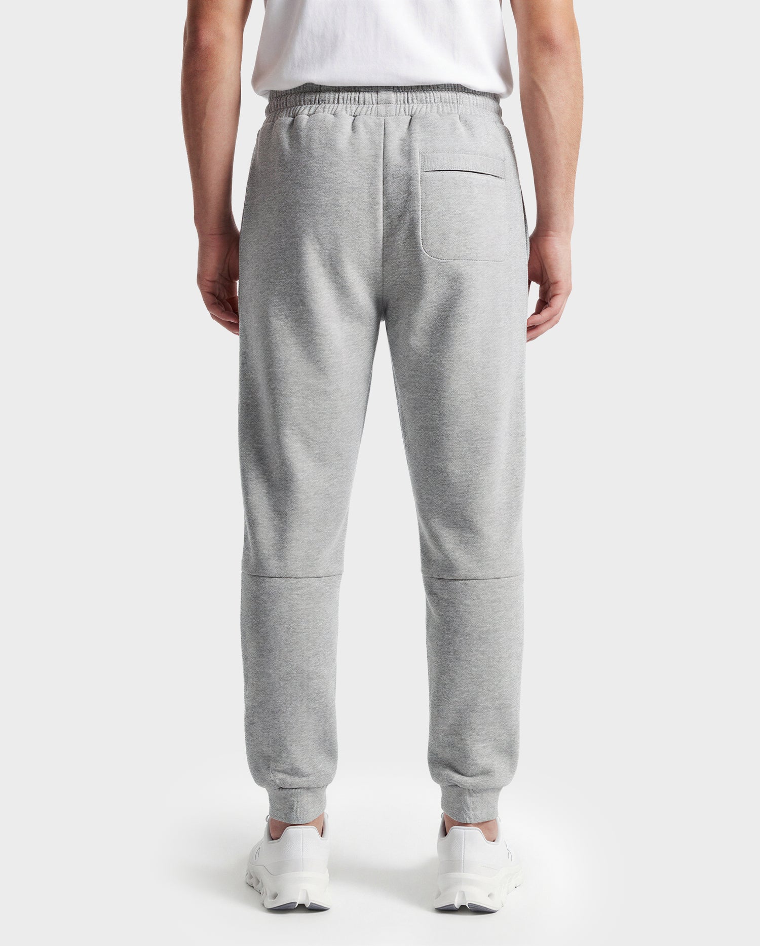 Wearing Rudsak's JOSS - 9524009 joggers in heather grey (M), a person with a white T-shirt and white sneakers stands with their back to the camera against a plain white background.