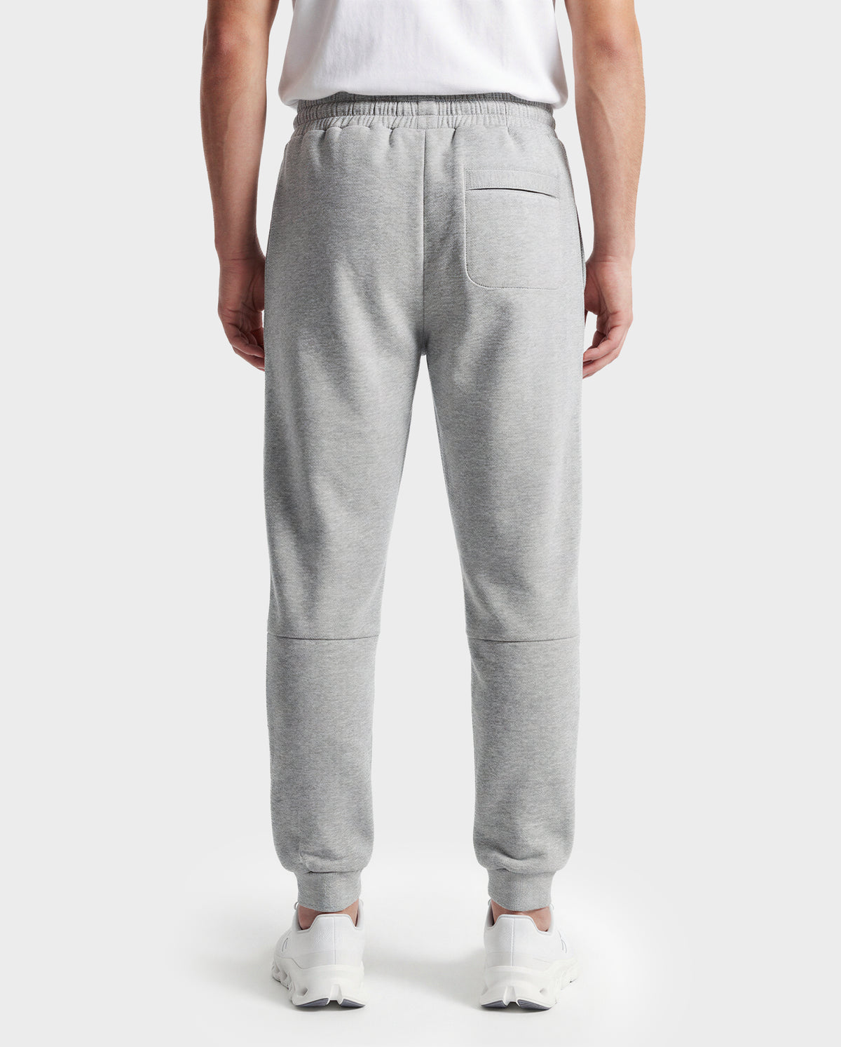 Wearing Rudsak's JOSS - 9524009 joggers in heather grey (M), a person with a white T-shirt and white sneakers stands with their back to the camera against a plain white background.