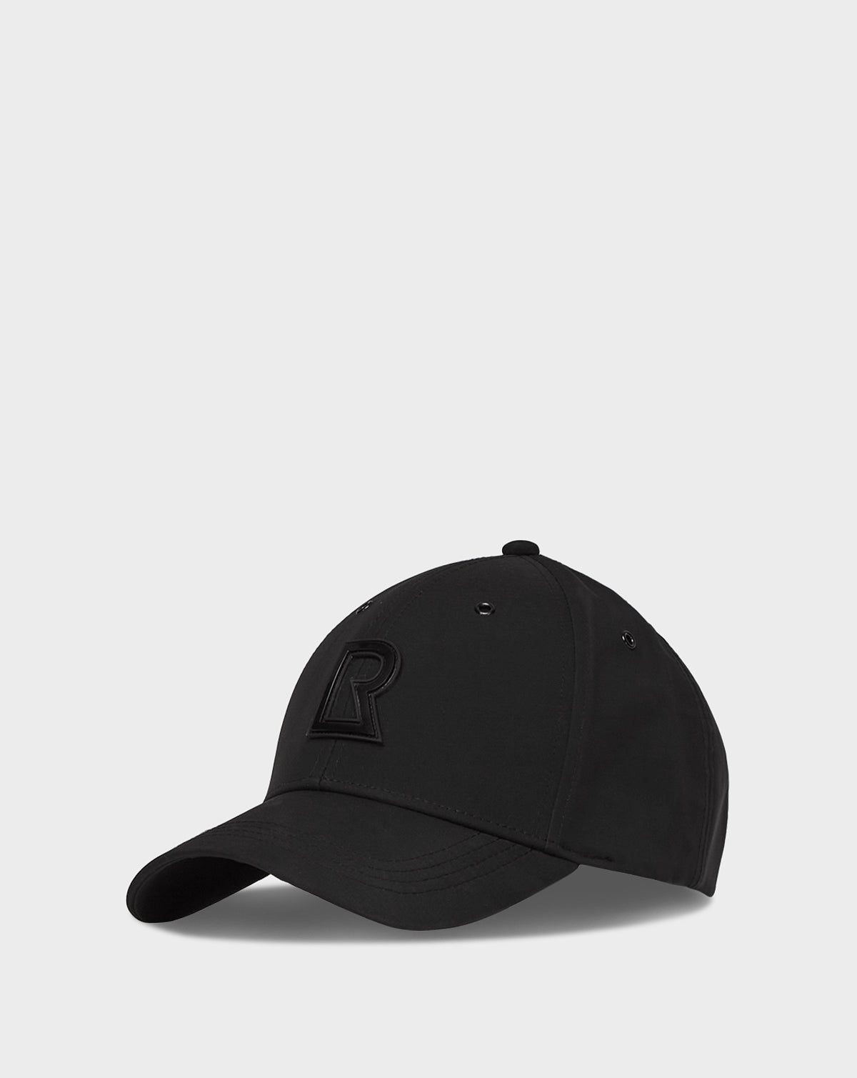 The ALDEN - 9422029 BLACK by Rudsak is a unisex adjustable baseball cap with a curved brim and an embroidered letter R on the front, shown against a plain light gray background.