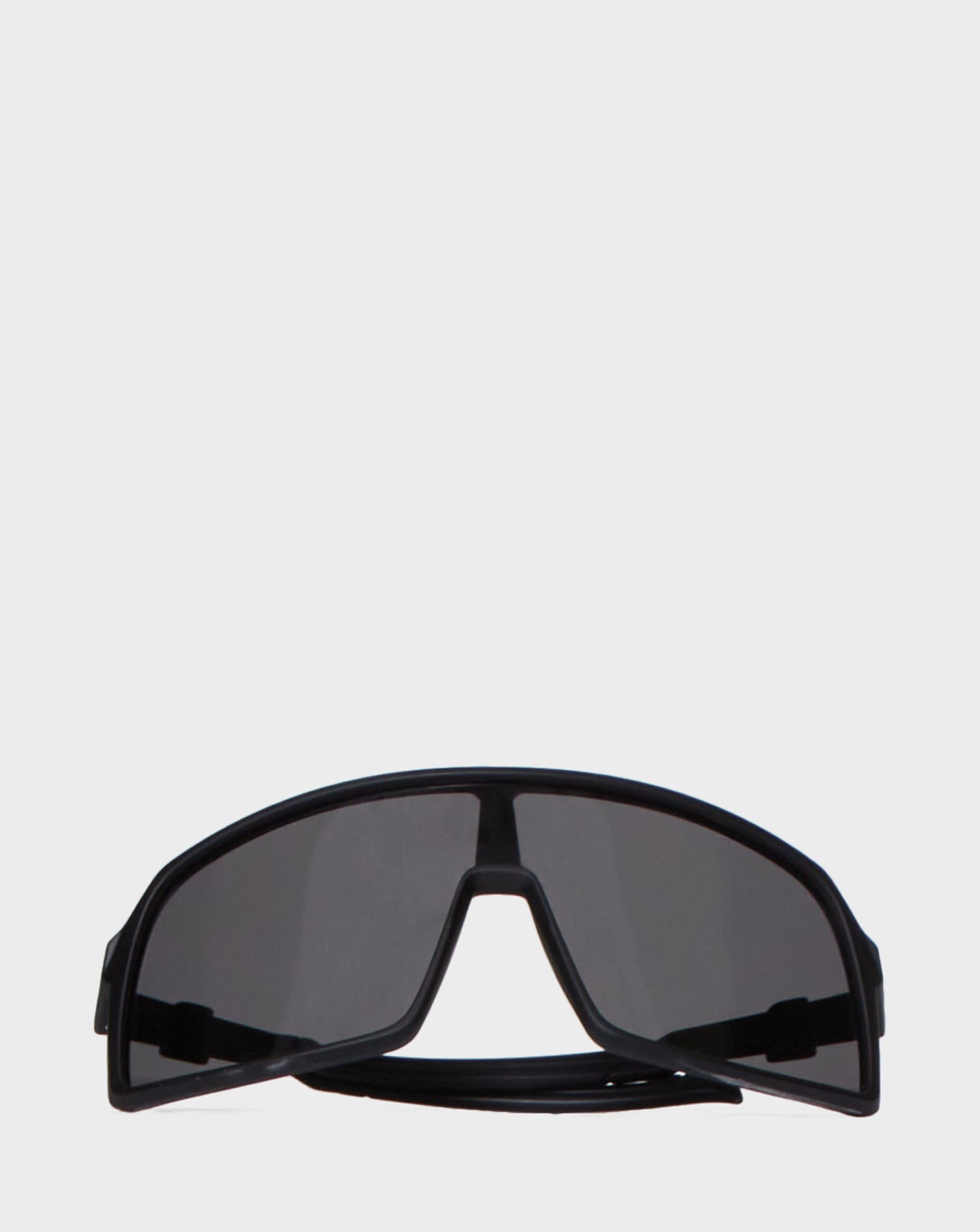 A pair of Rudsak AKSEL - 9422031 BLACK wraparound sunglasses with UV-block lenses and dark tinted shades, displayed on a plain white background.