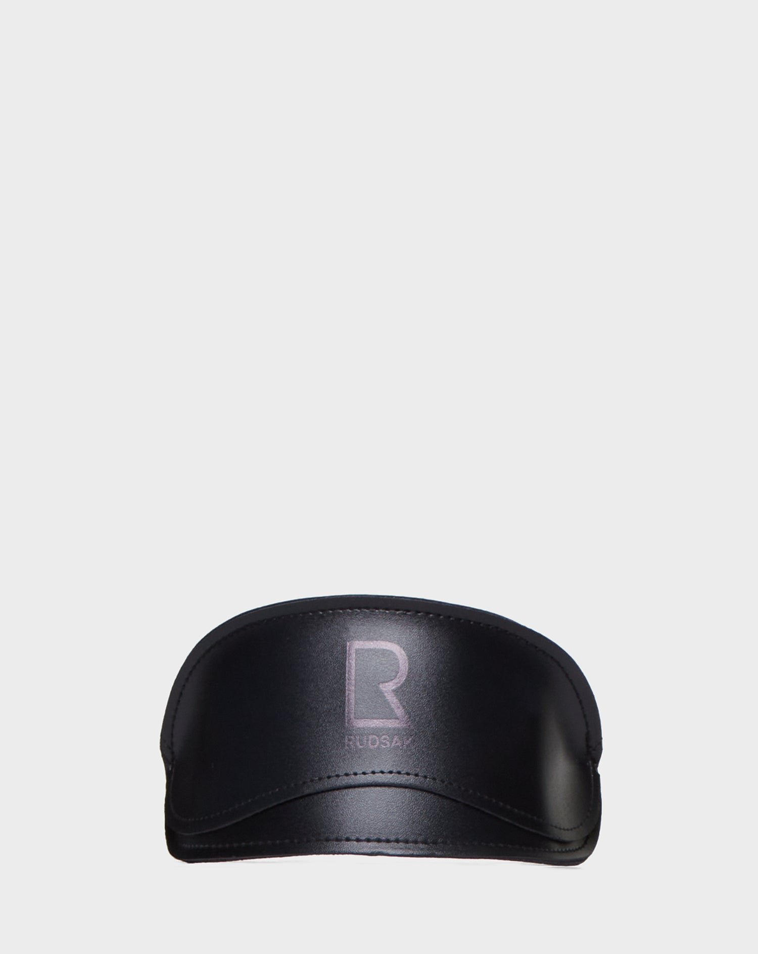 A black, shiny Rudsak visor featuring a bold "R" and "RUDSAK" on the front is paired with AKSEL - 9422031 BLACK sunglasses with UV Block Lenses, all set against a plain white background.