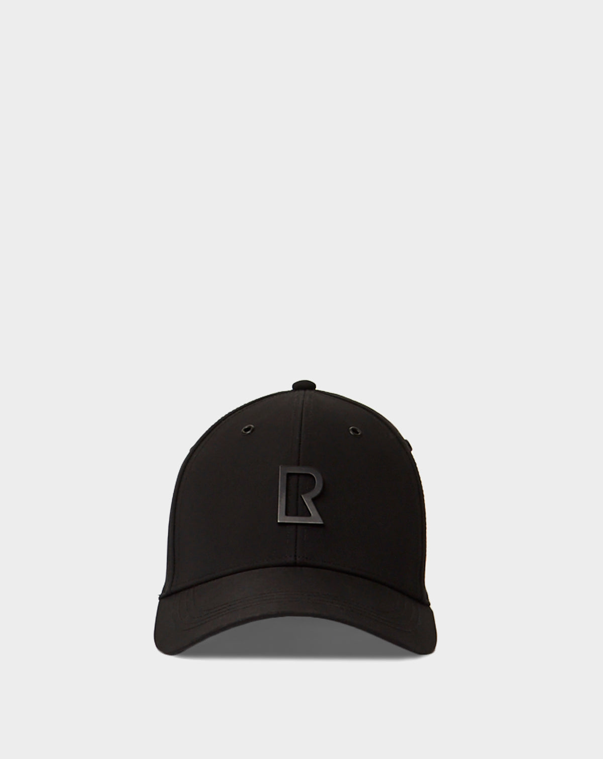 The Rudsak ARSENE - 9422504 Black is a black unisex baseball cap featuring a raised black R logo on the front, adjustable for comfort and style, shown against a plain light gray background.