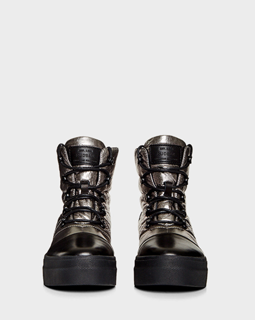 The Rudsak TASSEL - CA EN 8219514 SILVER are high-top metallic silver sneakers with black laces, thick black soles, and faux shearling details for warmth, shown from the front on a plain light gray background.
