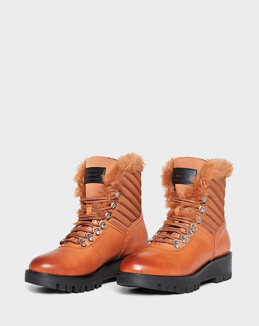 The Rudsak TSARY - CA EN L219530 TAN boots are tan leather lace-up winter boots with quilted sides, faux-fur ankle lining, black soles, and metal eyelets, shown on a plain white background.