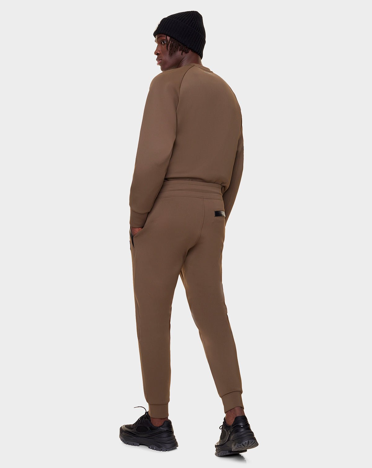 Wearing Rudsak’s OLAV - 9522503 ARMY MEN joggers, a person stands facing away and looks over their shoulder against a plain light gray background.