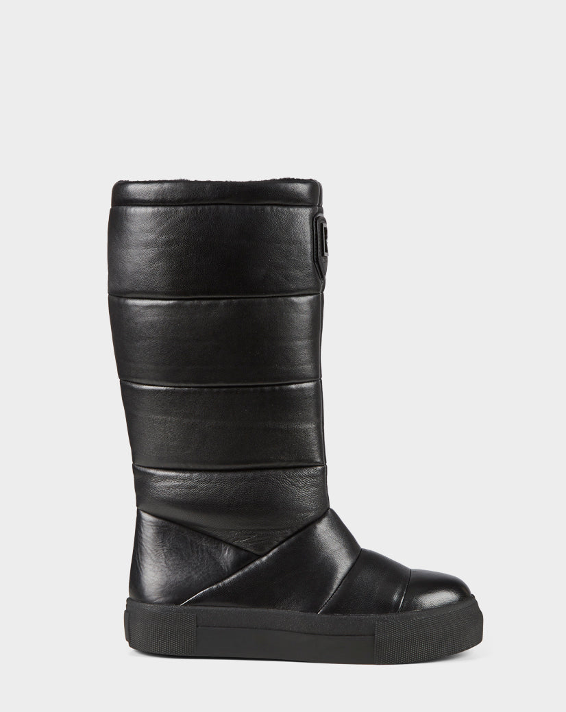 The TEIGEN - CA EN 8220533 BLACK by Rudsak is a black, mid-calf quilted leather winter boot with a flat rubber sole and horizontal stitching, shown in side profile against a plain white background.