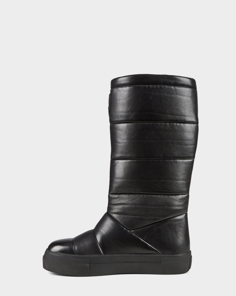 The TEIGEN - CA EN 8220533 BLACK by Rudsak is a black, quilted leather mid-calf boot with a flat rubber sole and rounded toe, shown in profile against a plain white background.